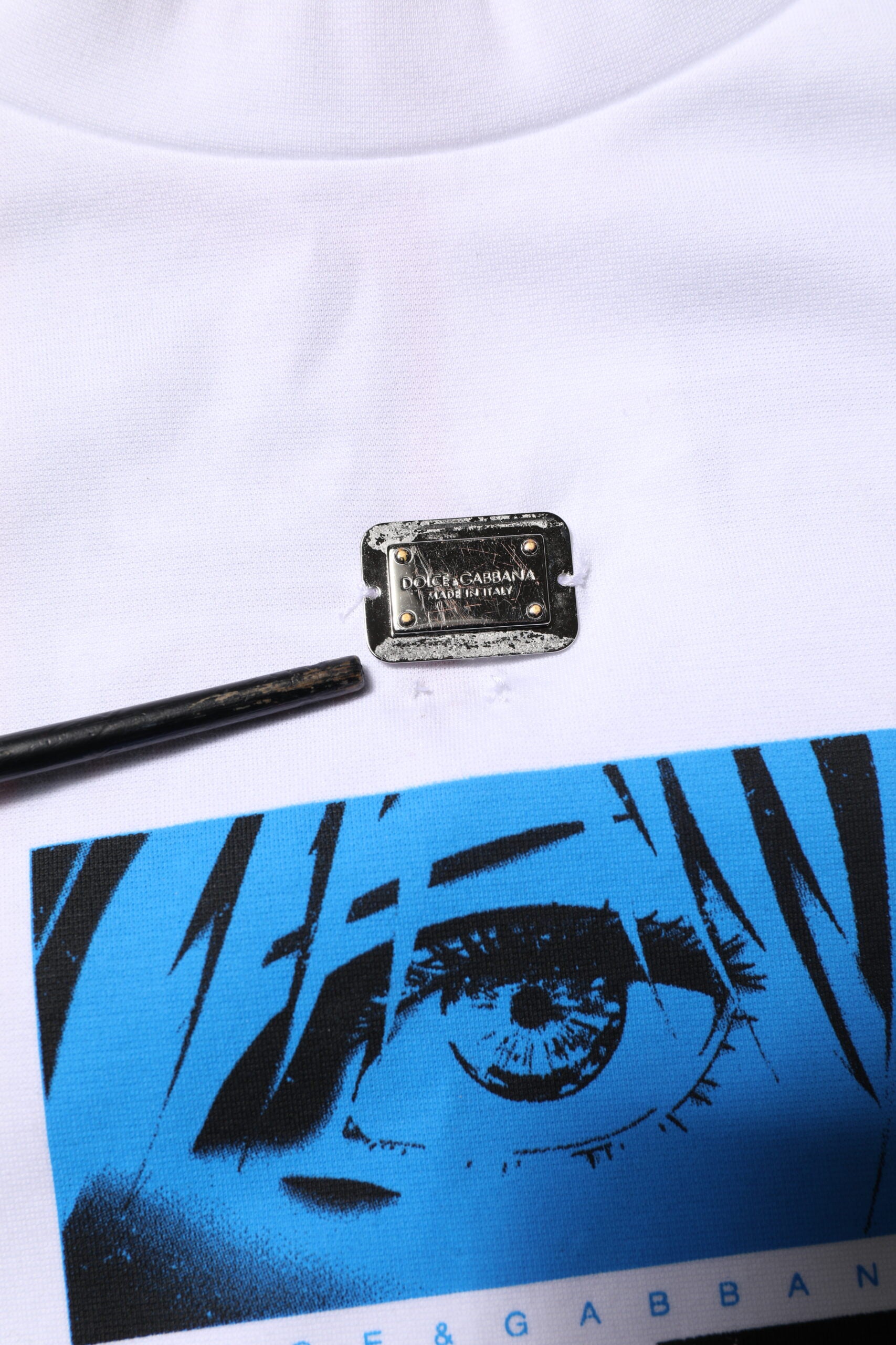 White t-shirt with blue graphic featuring an eye