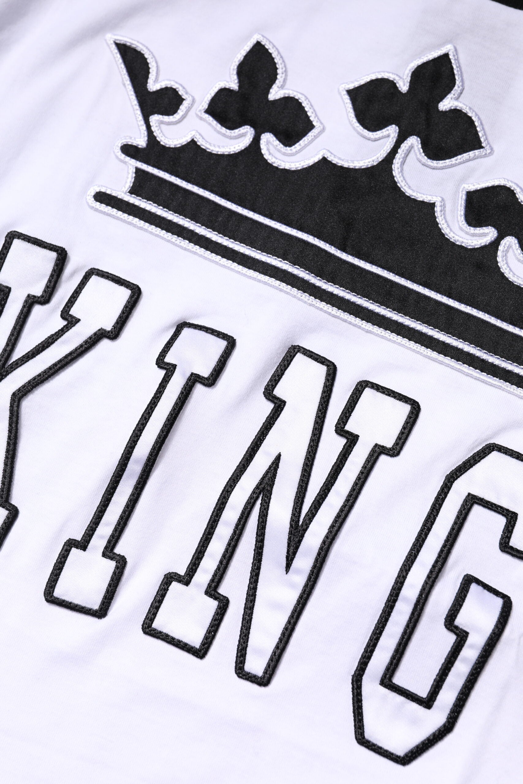 White t-shirt with black embroidered crown and text