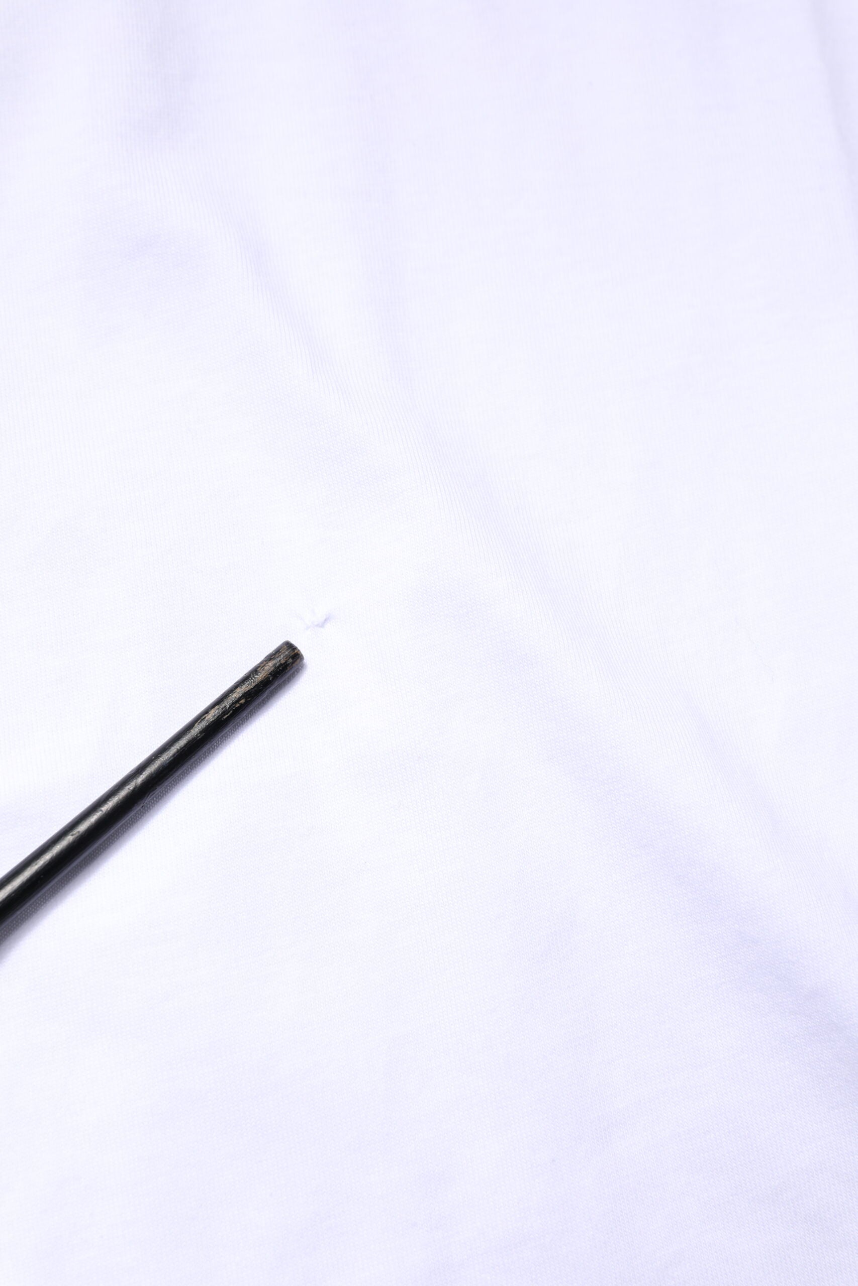 Small black object on white fabric