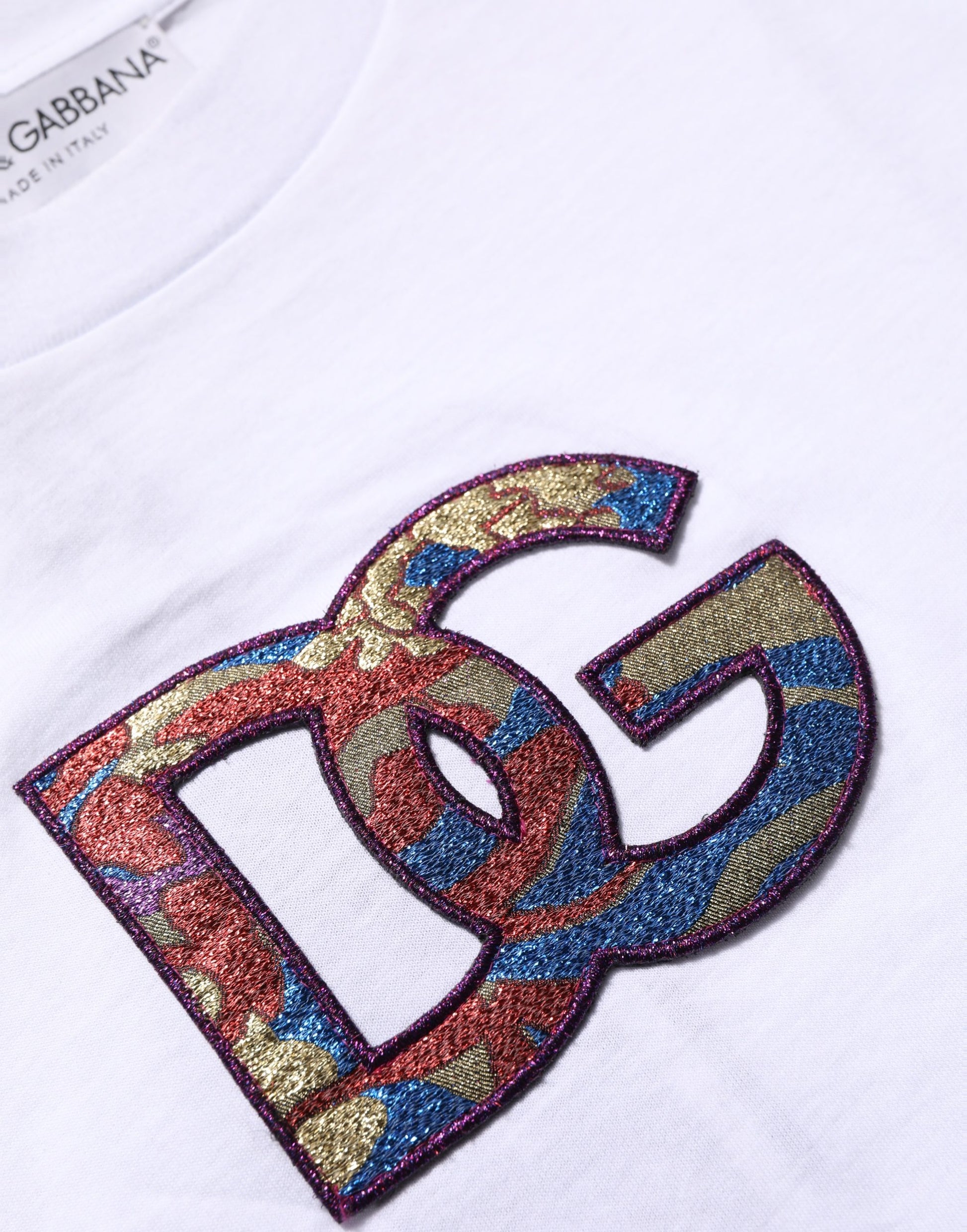 A white cotton t-shirt with a colorful embroidered logo patch