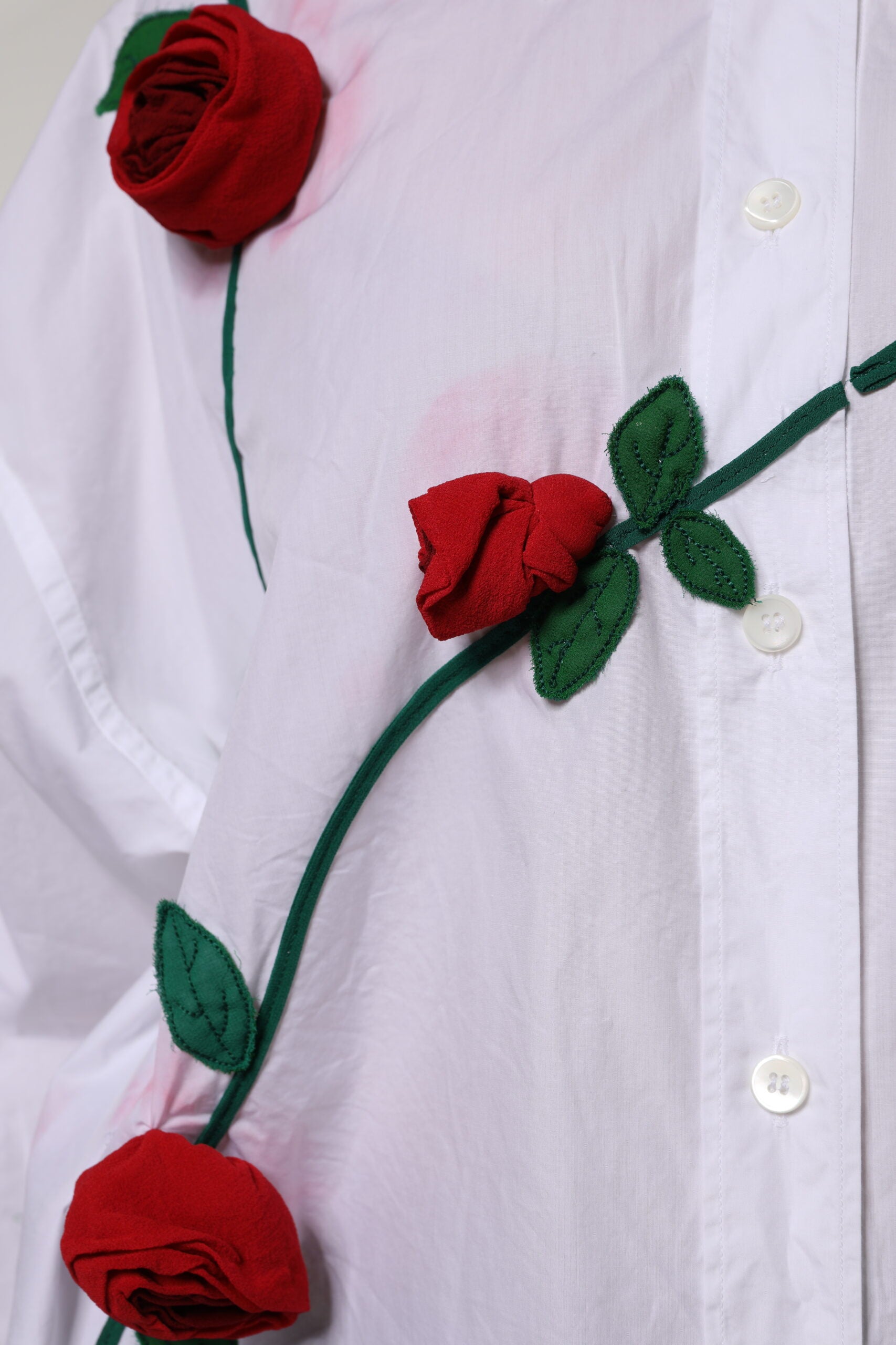 A white cotton dress shirt with floral applique roses and green stems