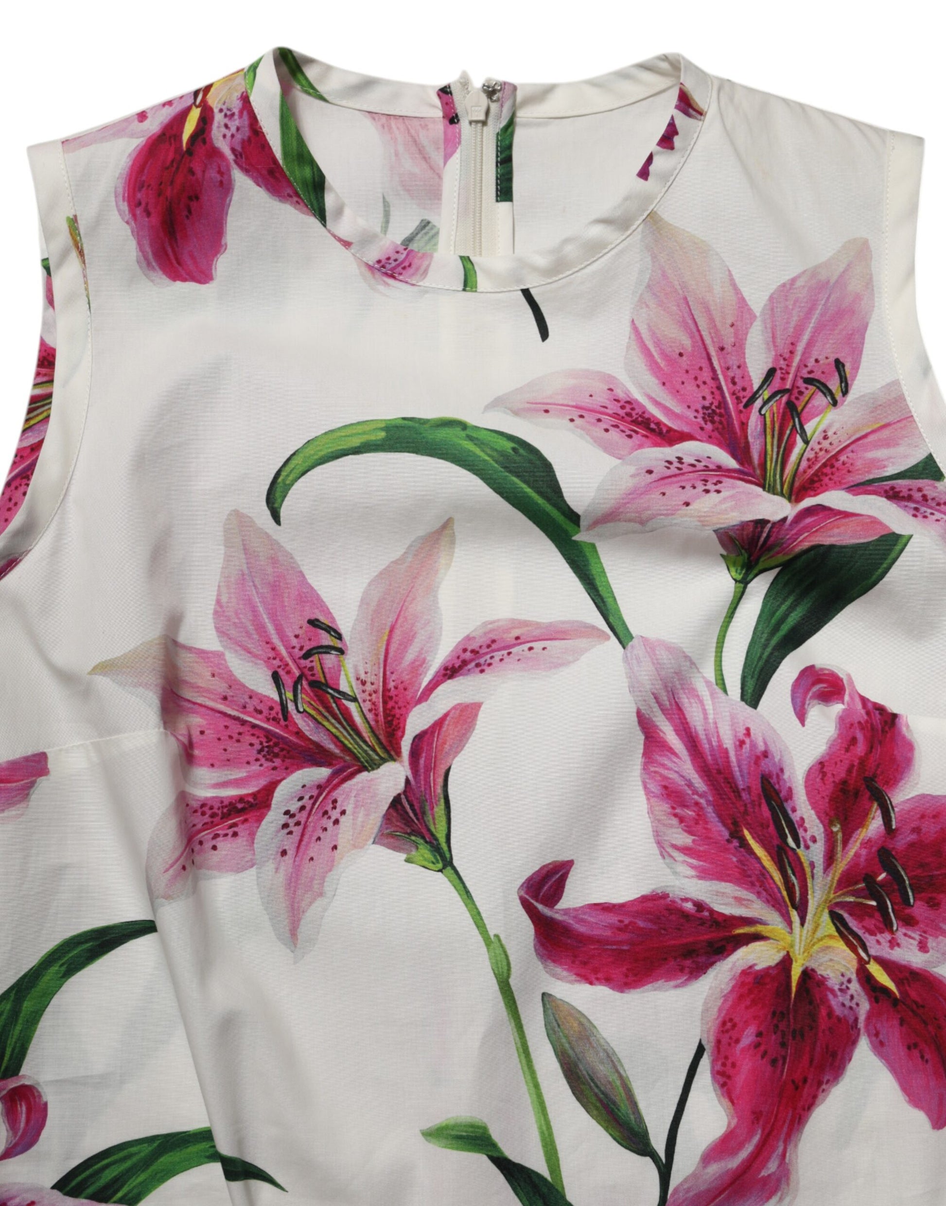 A sleeveless white cotton dress with a floral pattern featuring pink and green lilies