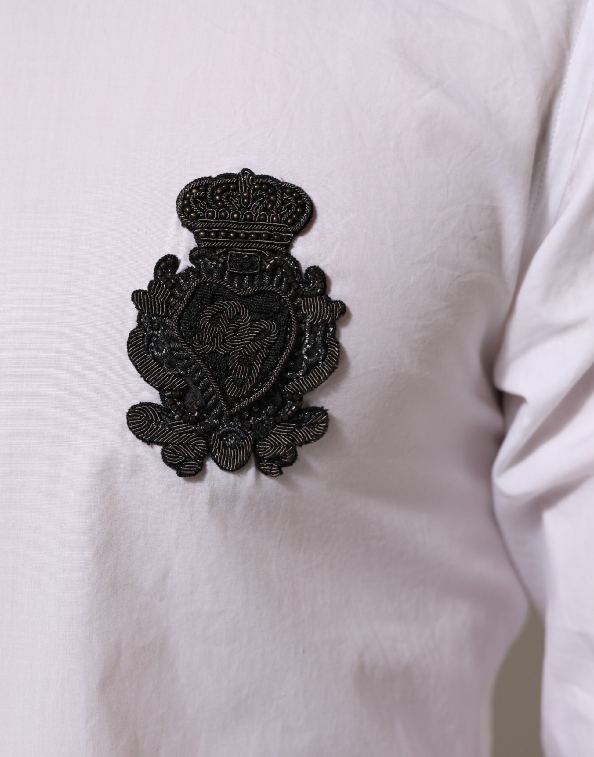 Gold embroidered patch on white cotton shirt