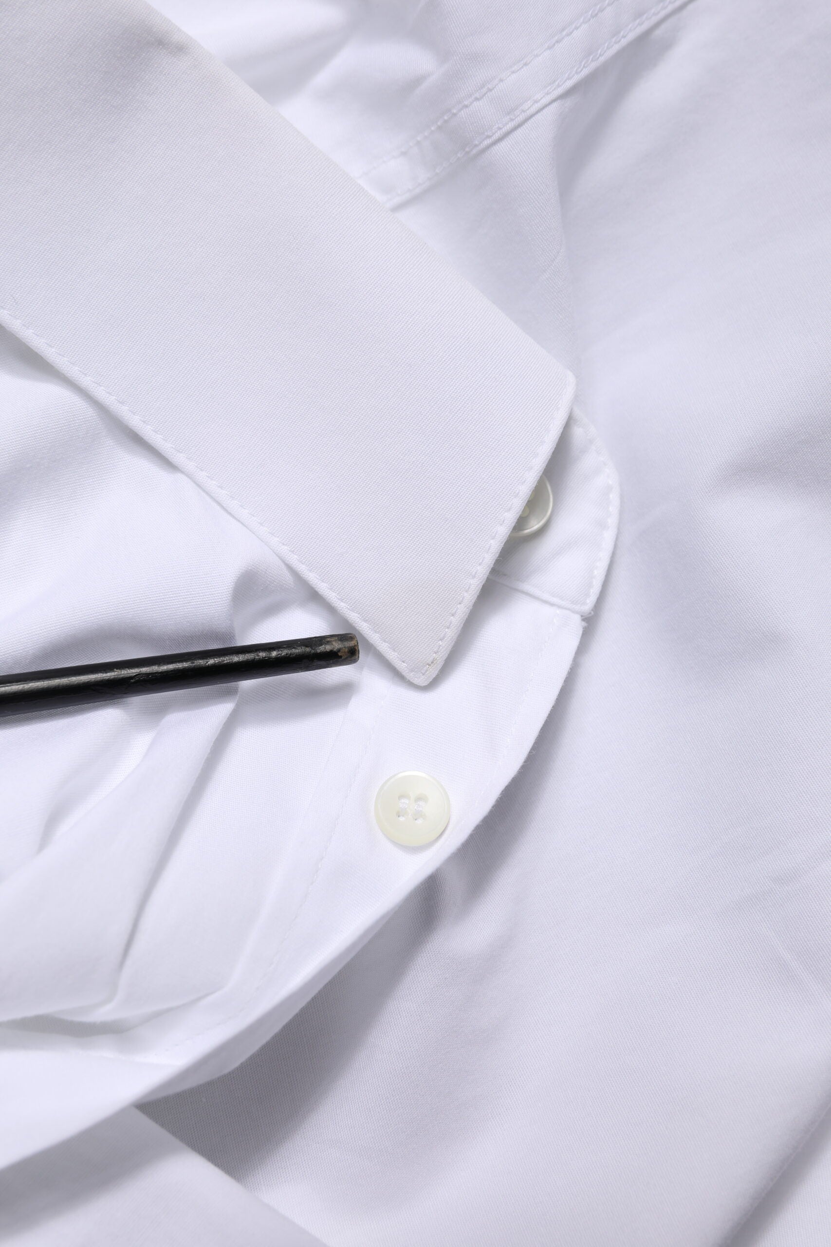 A white cotton dress shirt with a gold button and collar, by Dolce & Gabbana