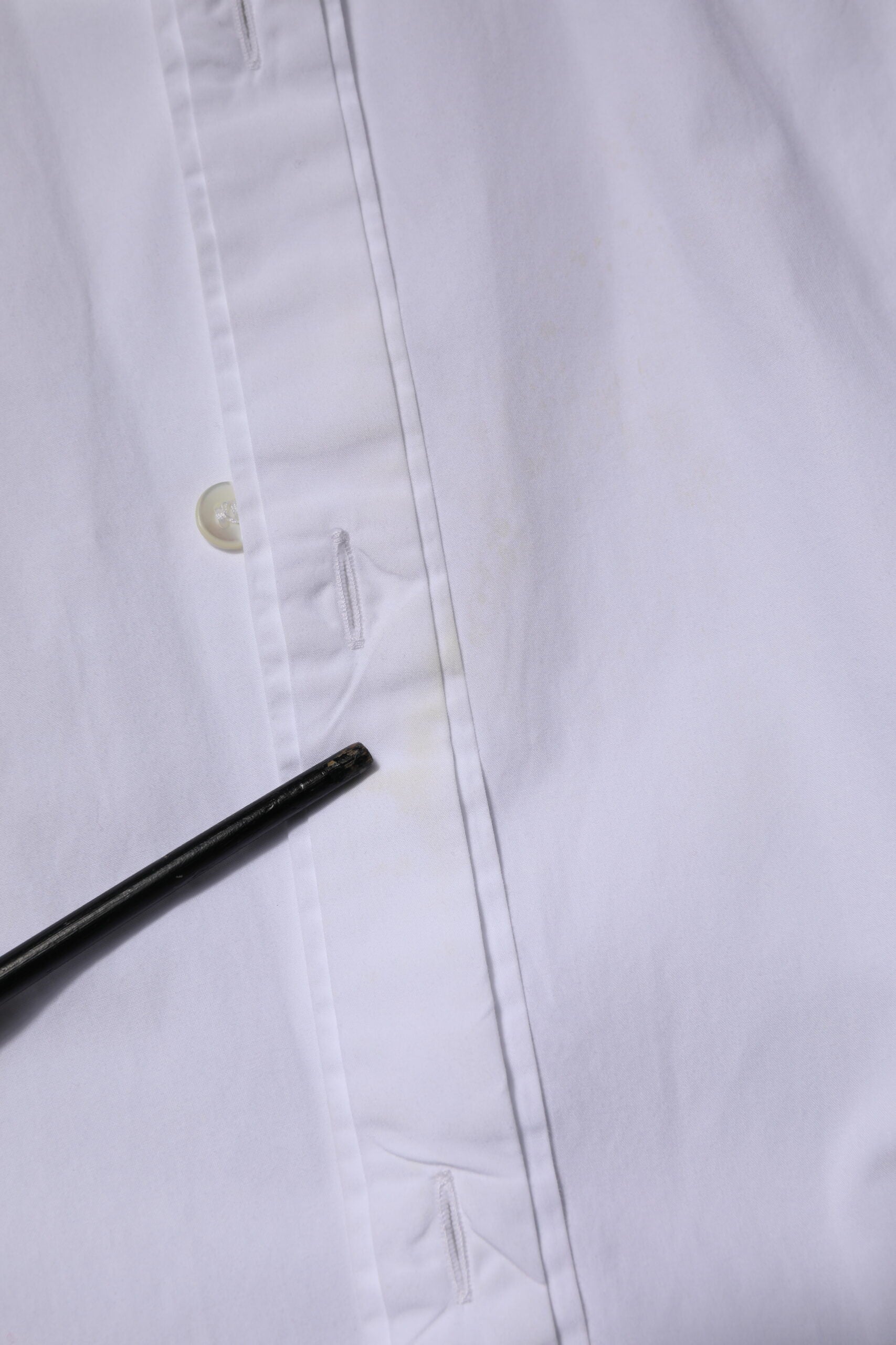 A white cotton dress shirt with long sleeves, featuring a gold design