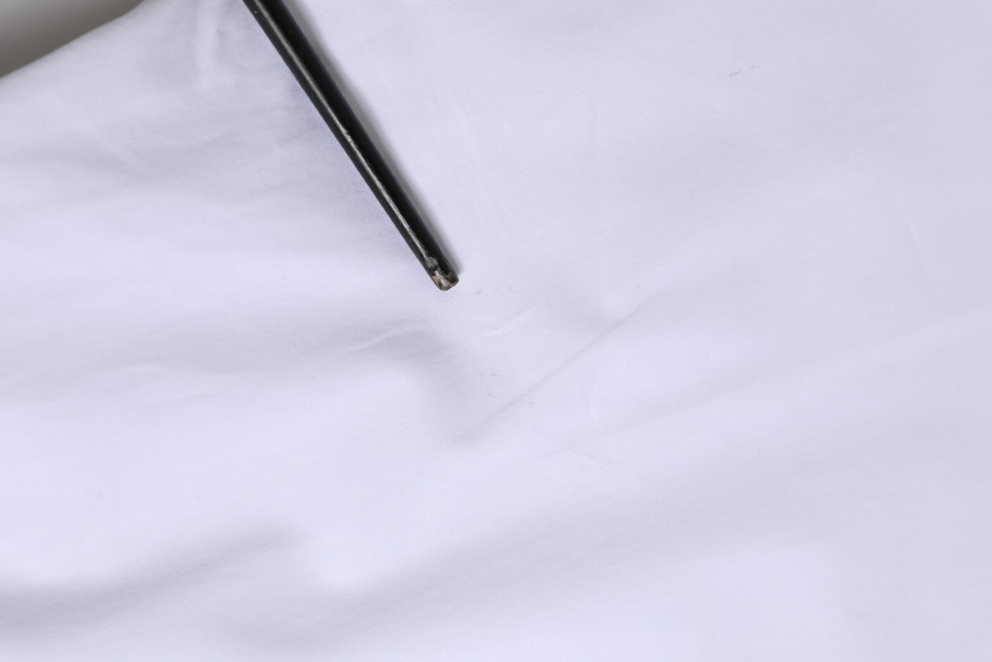A white cotton dress shirt with long sleeves, featuring a gold design