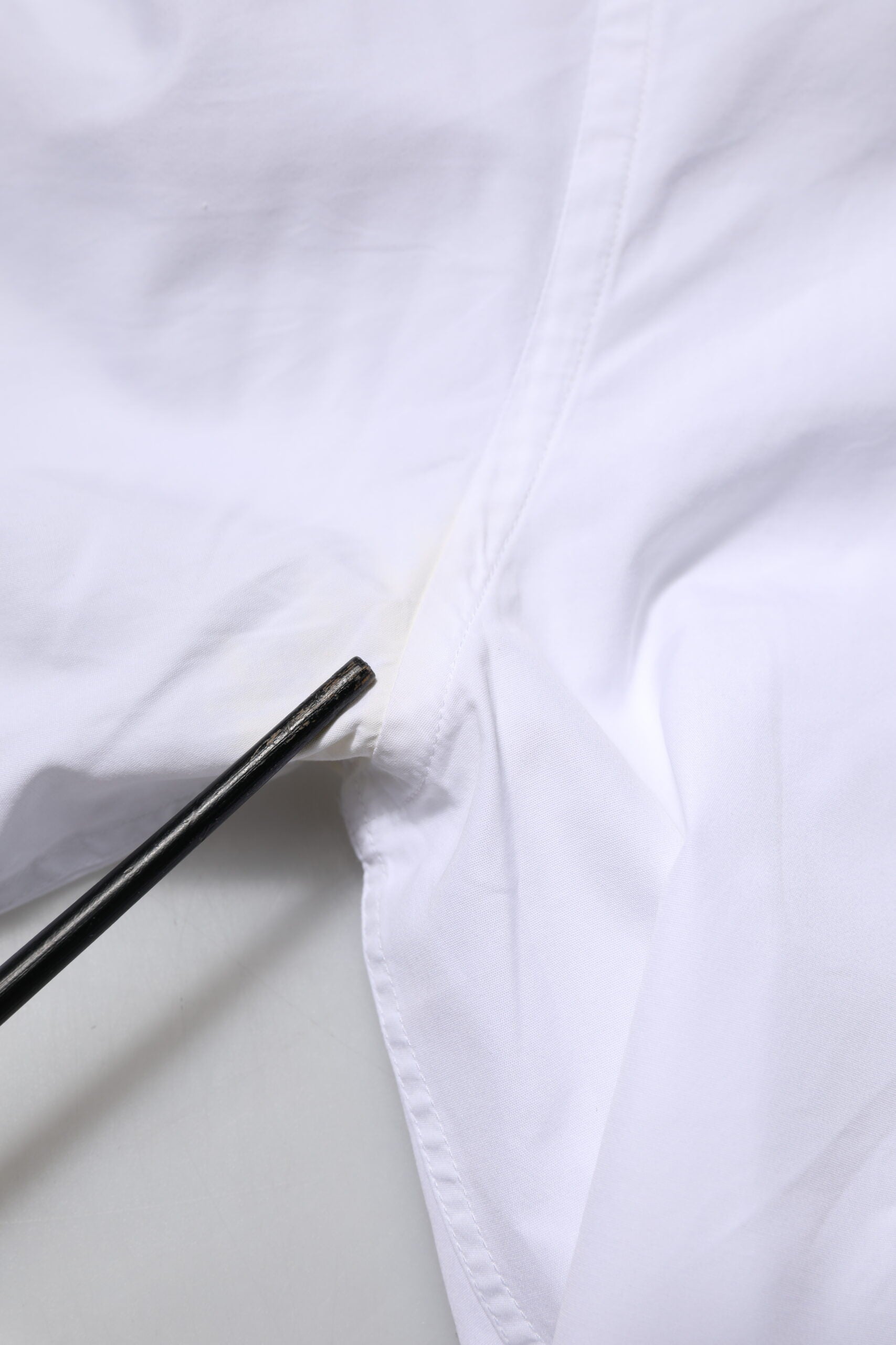 A white cotton dress shirt with long sleeves, featuring a gold design