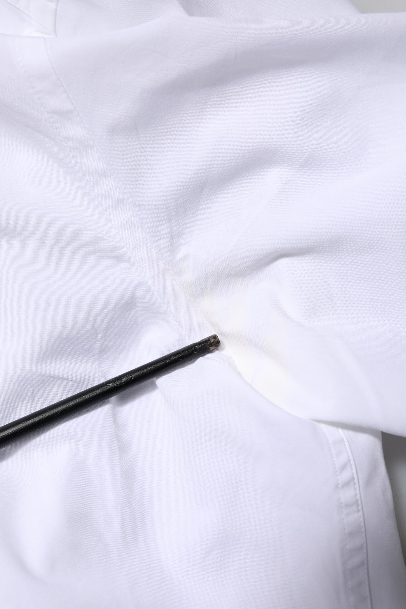 A white cotton dress shirt with long sleeves, featuring a gold design