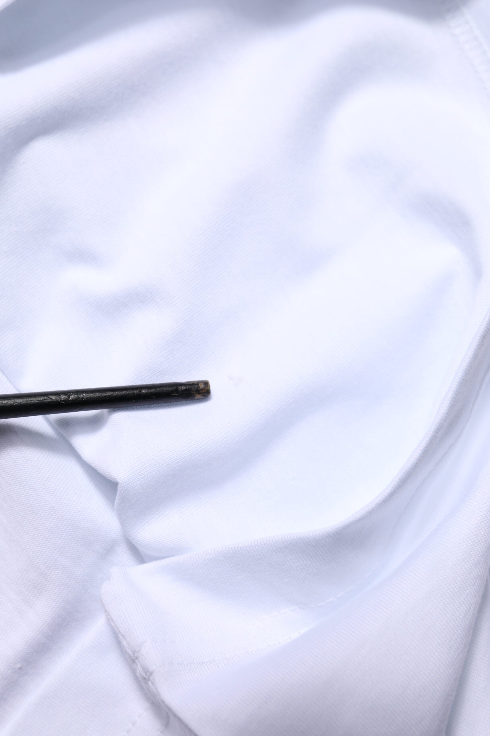 Black button on white fabric