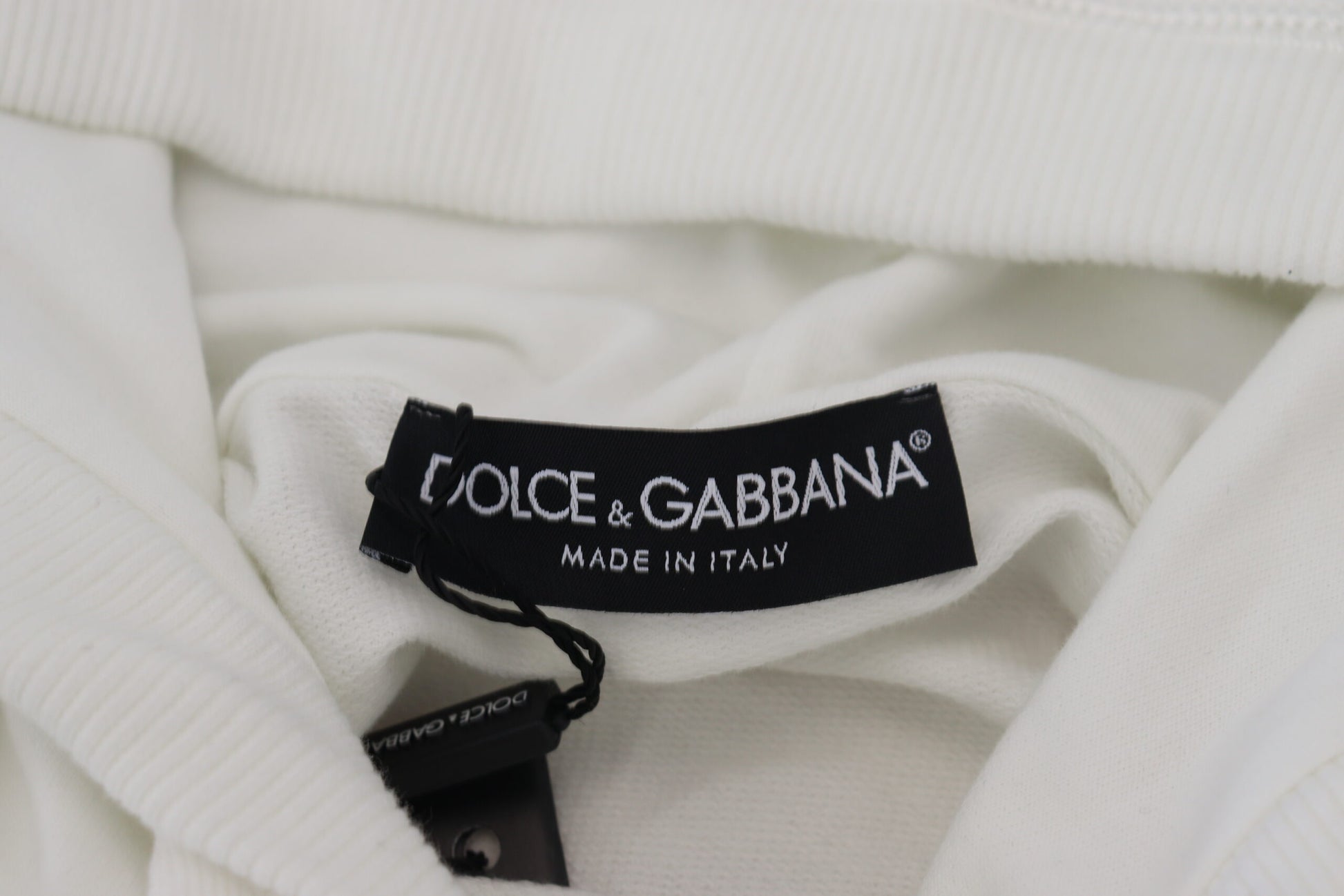 White sweater with black label that reads "GUCCI