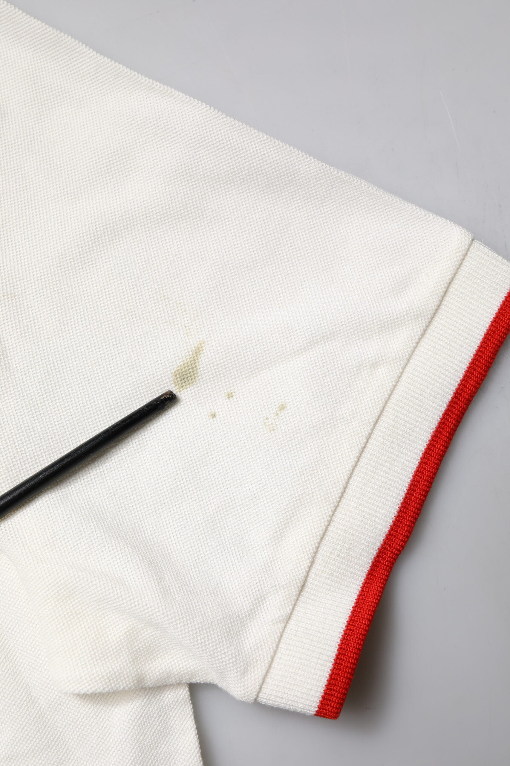 White shirt with red stripe on sleeve