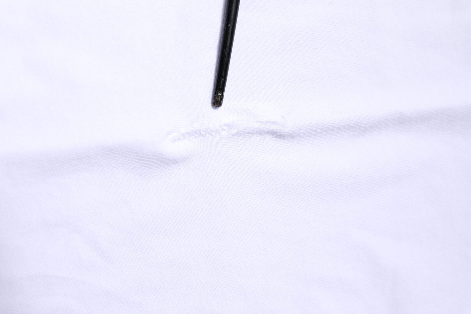 White fabric with a small hole in it
