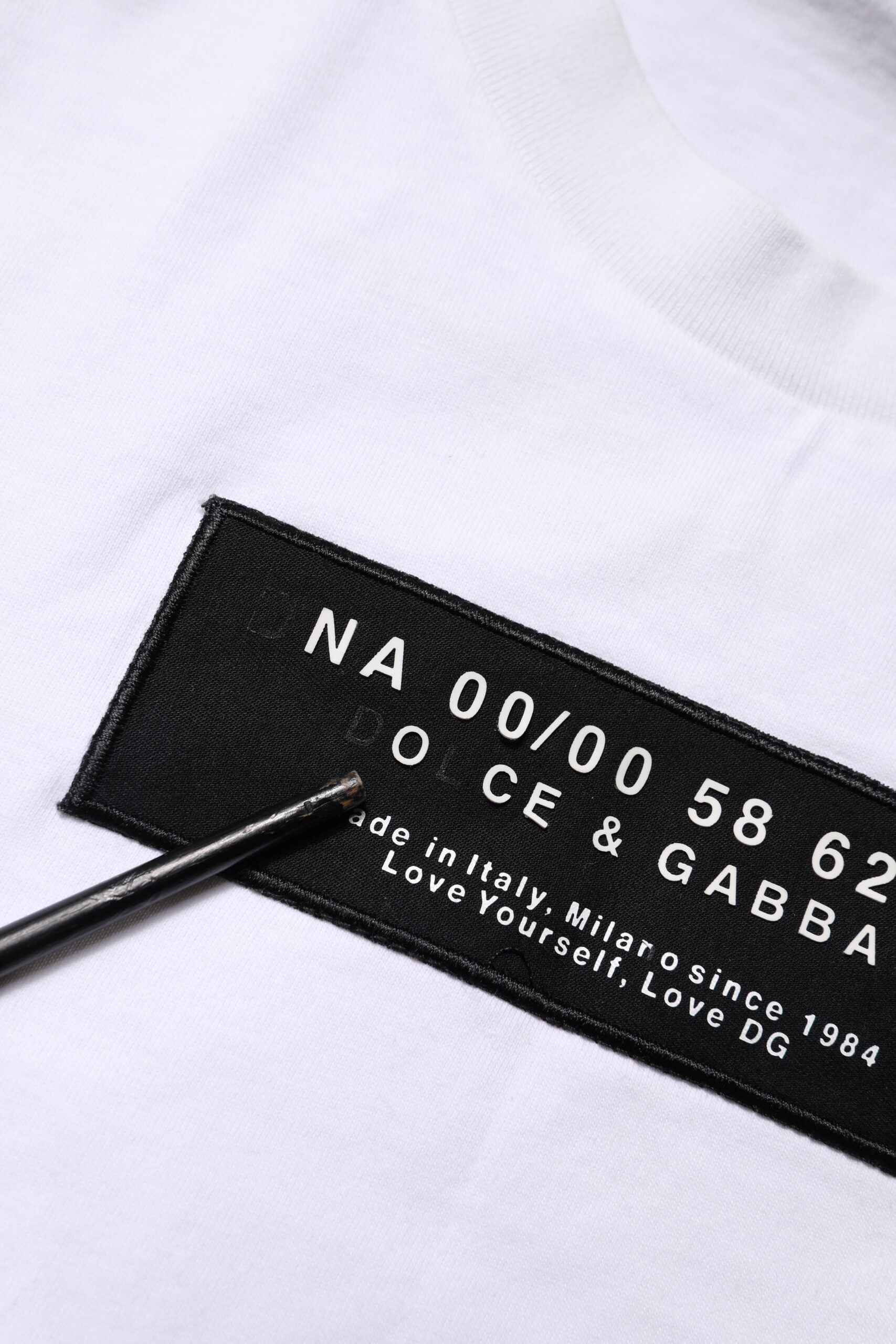 Black label on white shirt with handwritten numbers