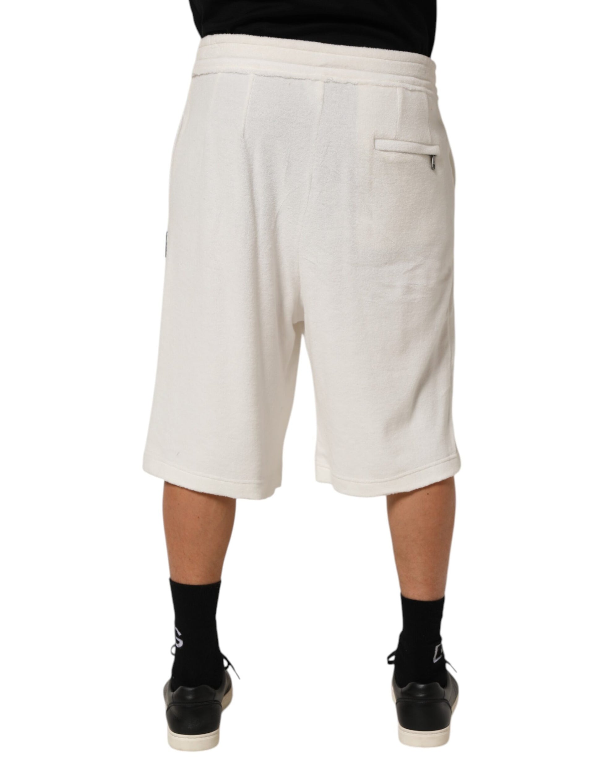 Man wearing white shorts and black shoes