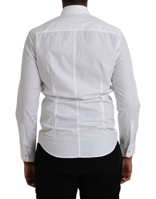 A white cotton long sleeve dress shirt with a collar and button-down front. It is designed by Dolce & Gabbana