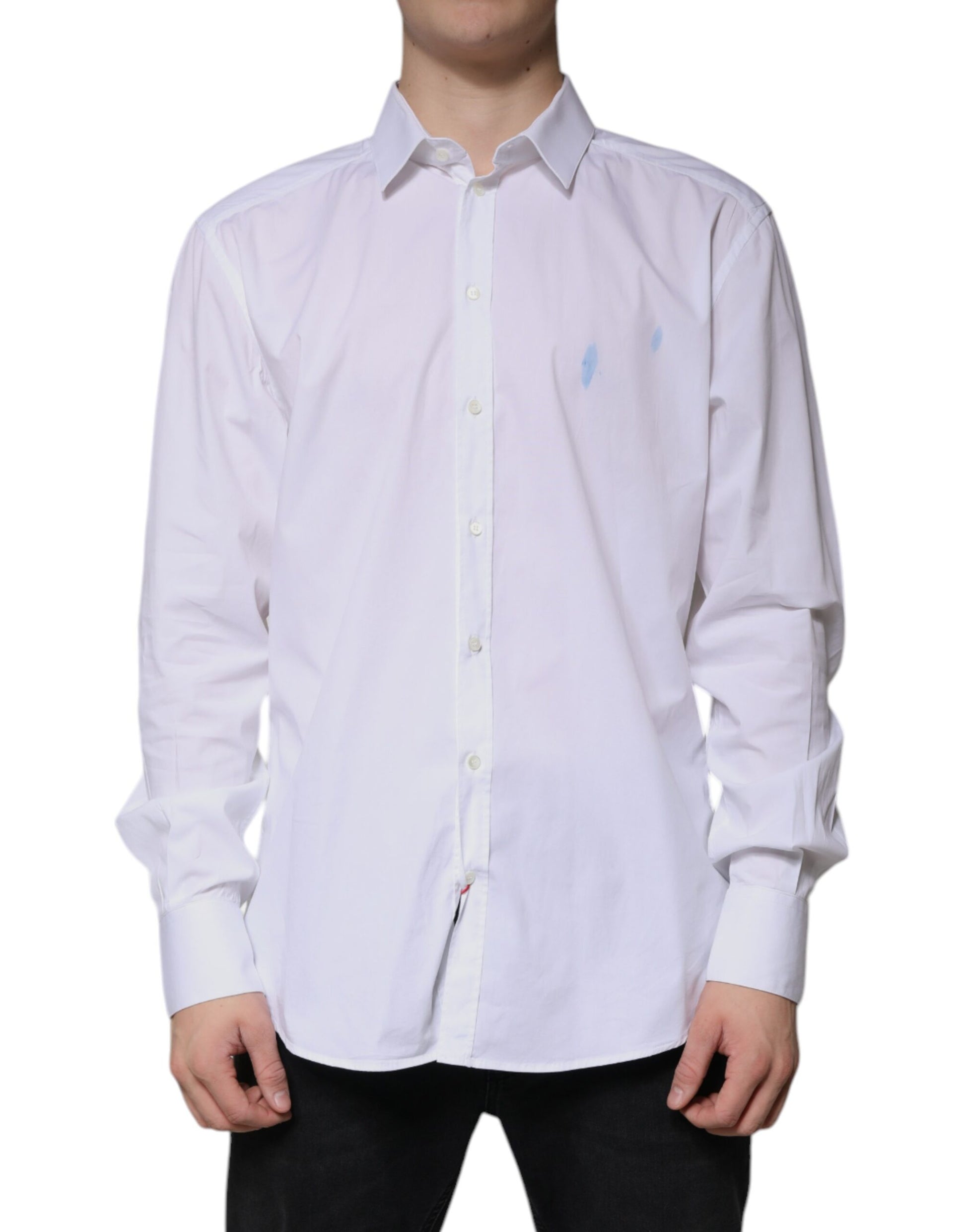 A long sleeved white cotton dress shirt with a gold emblem on the left chest