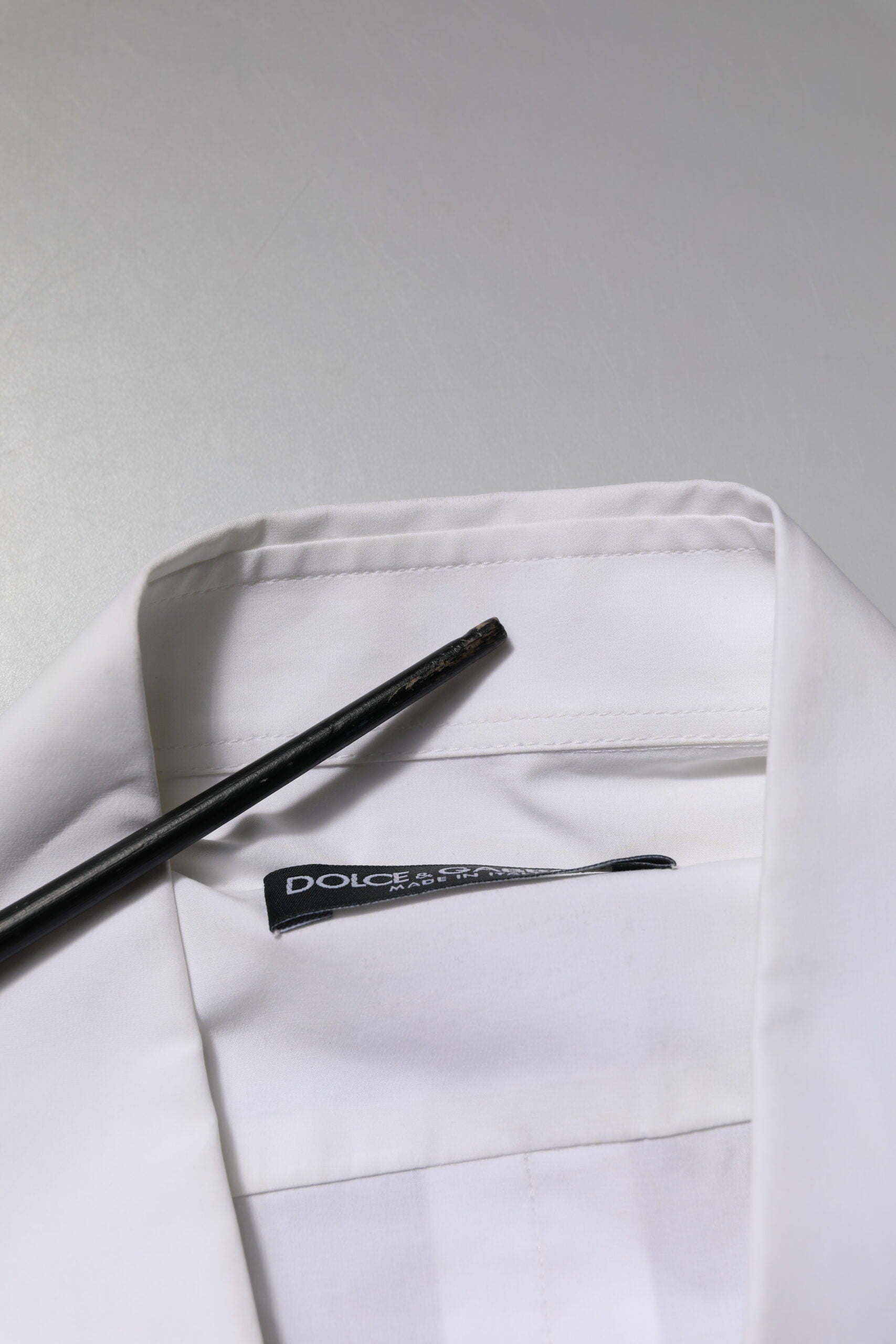 A white cotton long sleeve dress shirt with a black tie and cufflinks