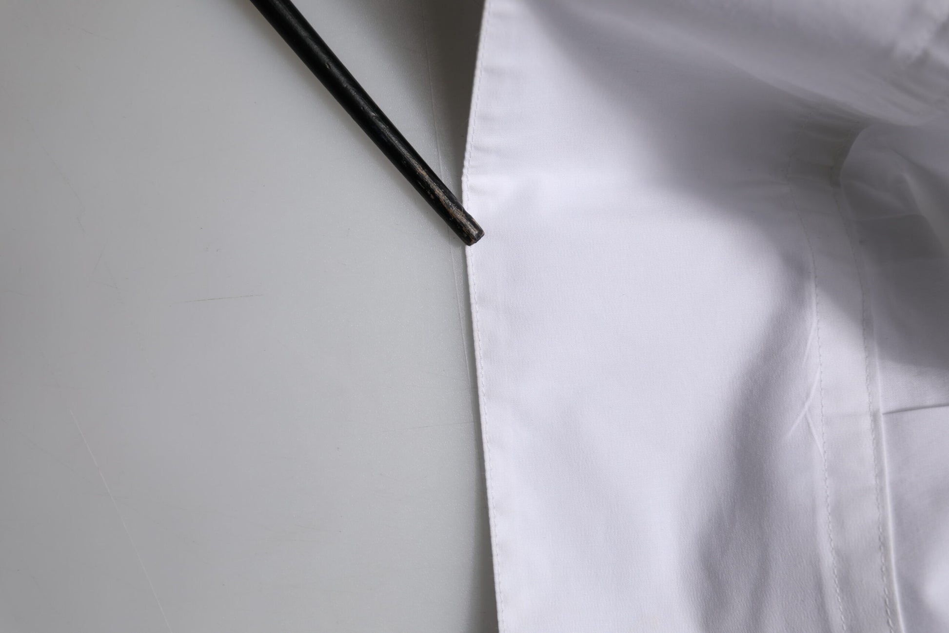 A white cotton long sleeve dress shirt with a collar and button closure