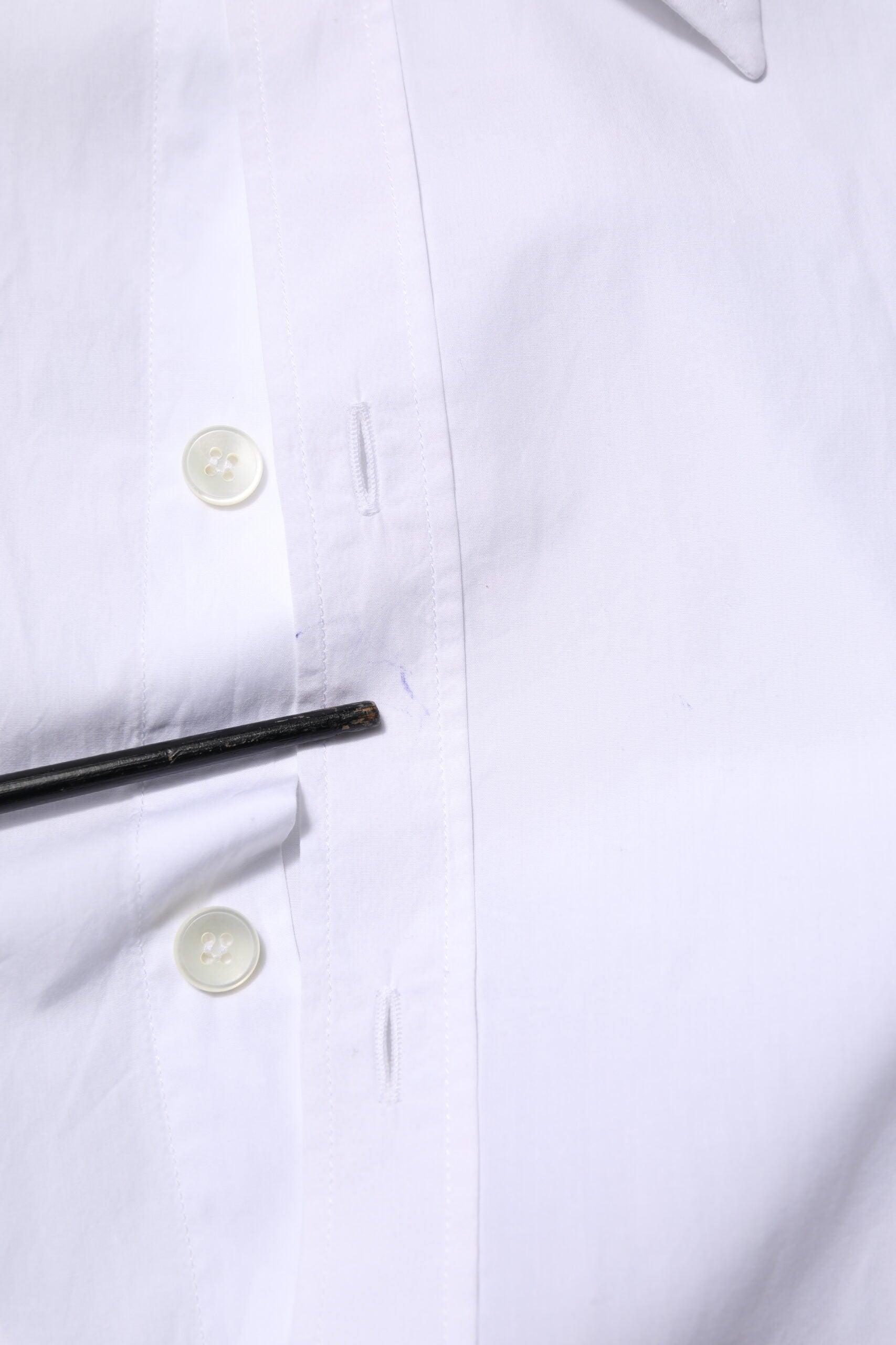 A white cotton dress shirt with long sleeves, two buttons, and a collar