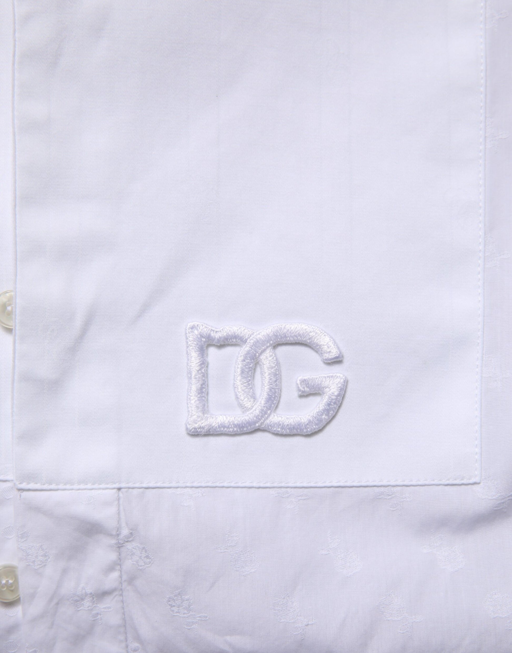 A white cotton shirt with a silver embroidered logo on the left chest