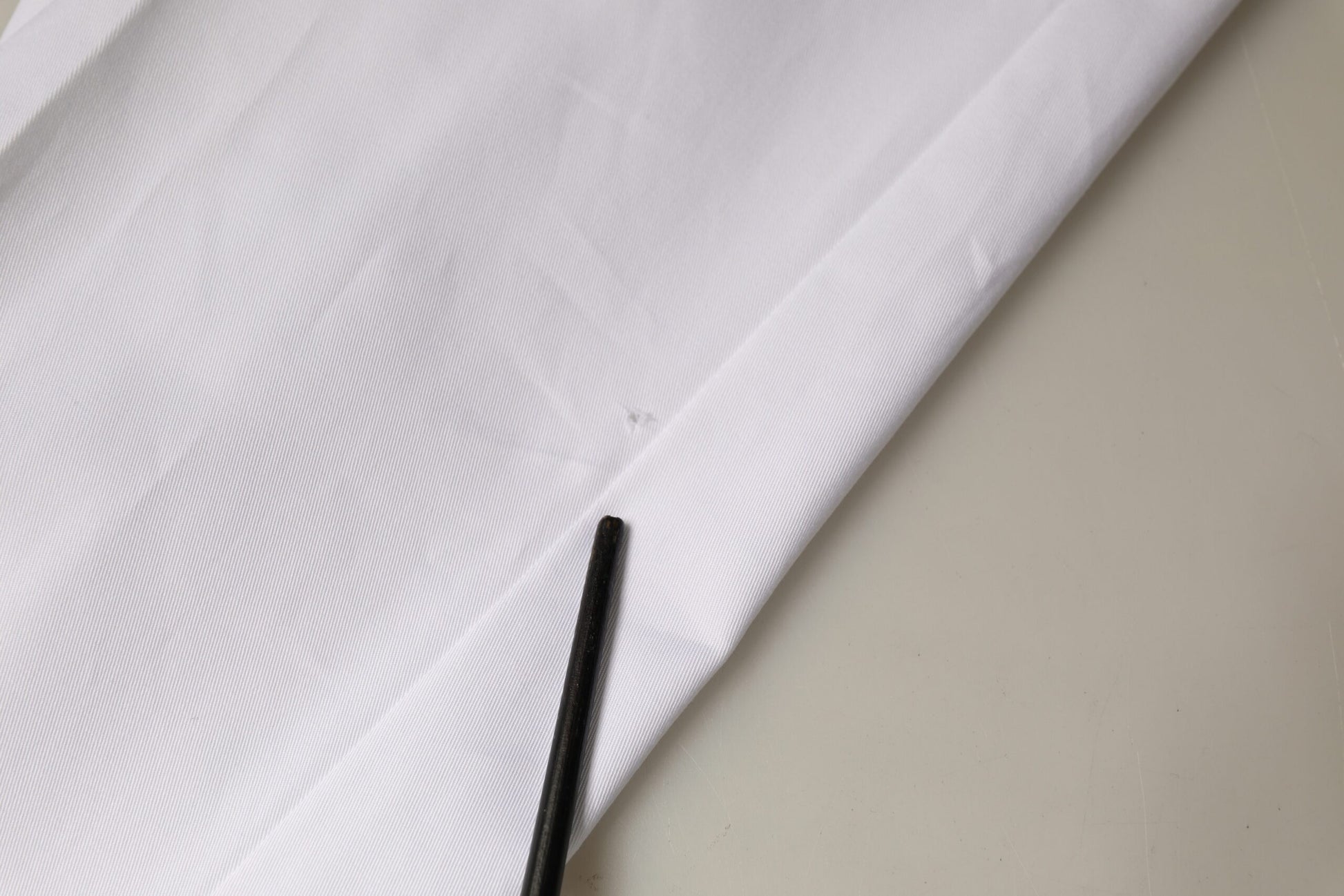 Black button on white fabric