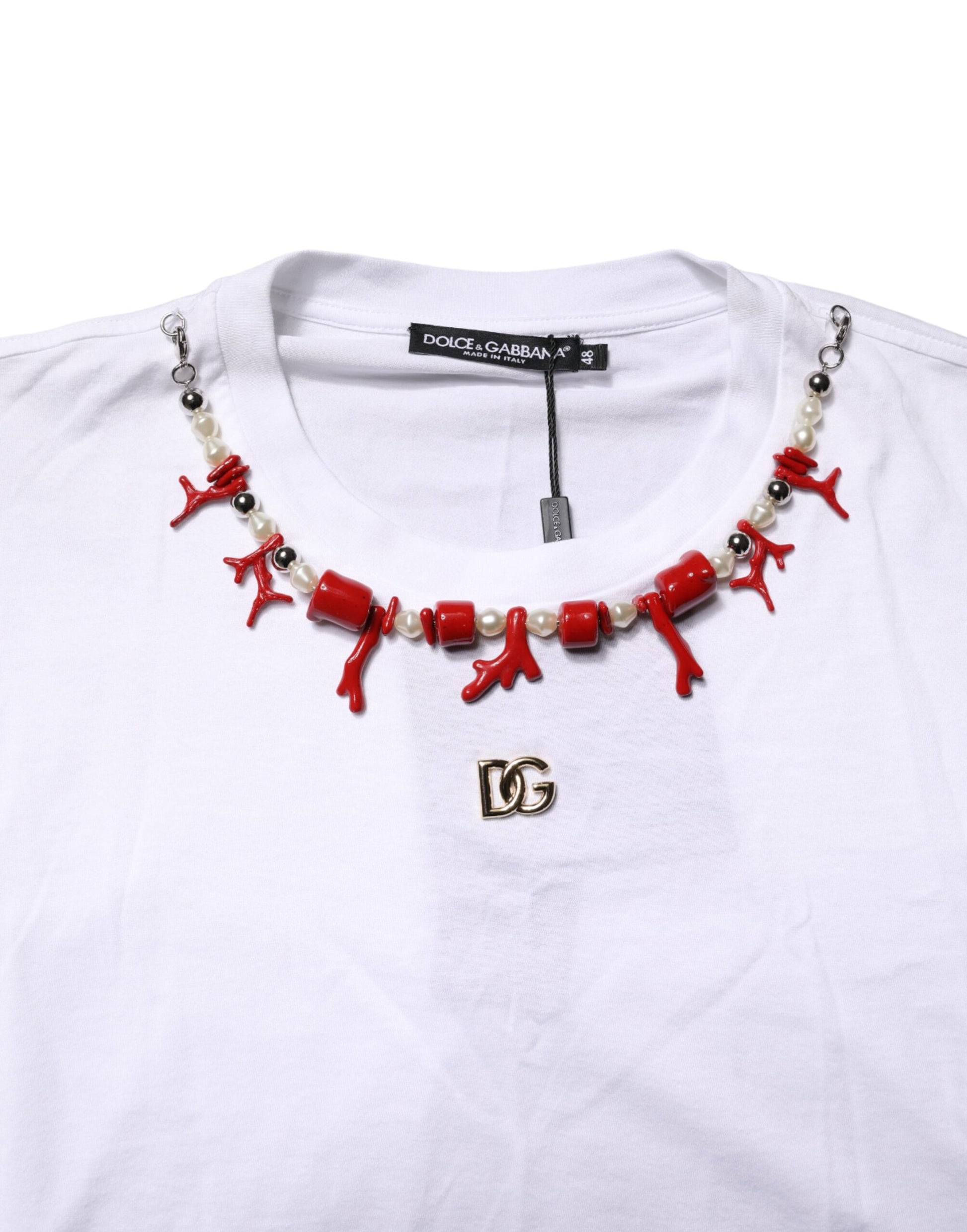 White t-shirt with red necklace featuring beads and a pendant