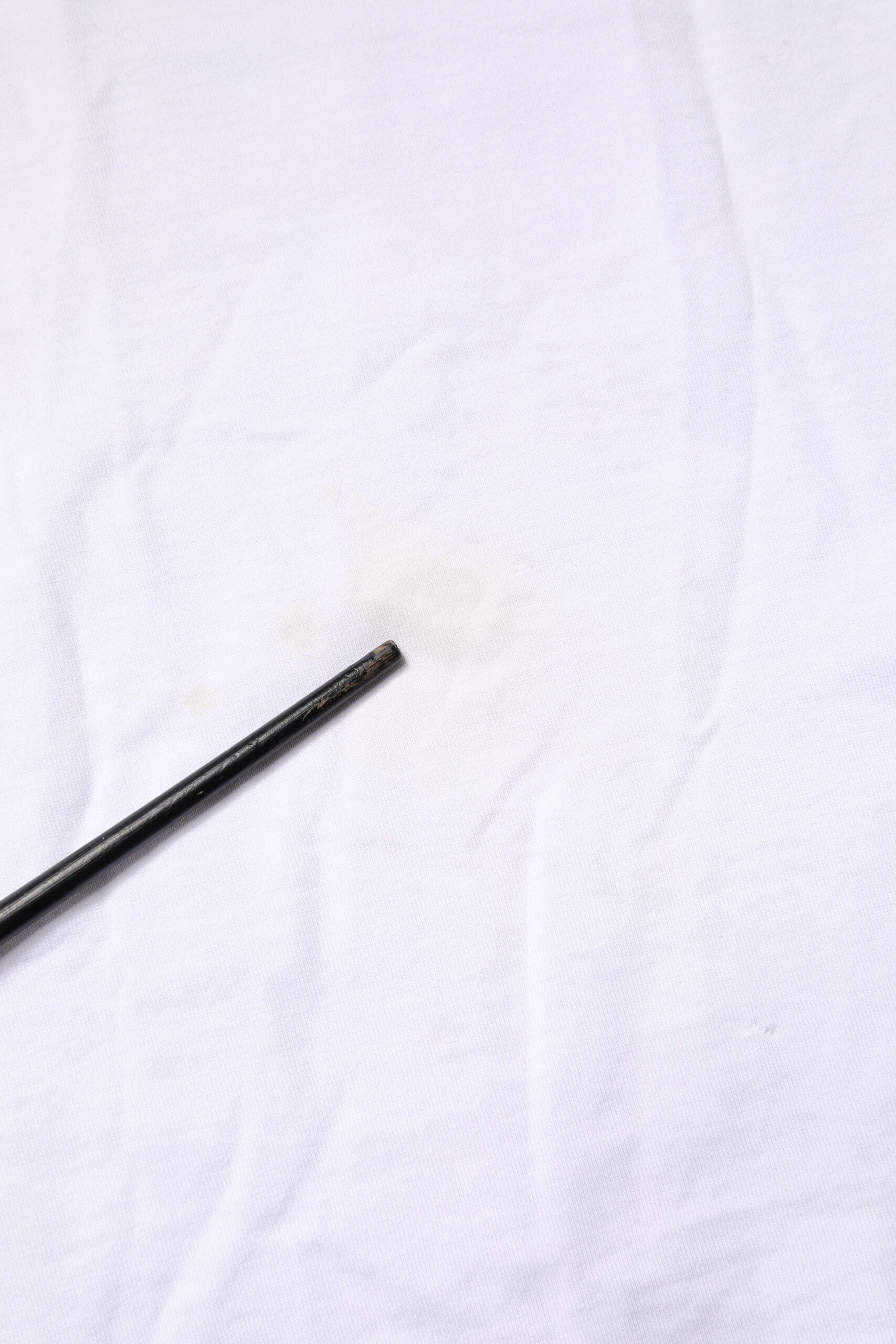 Small black metal screw on white cloth