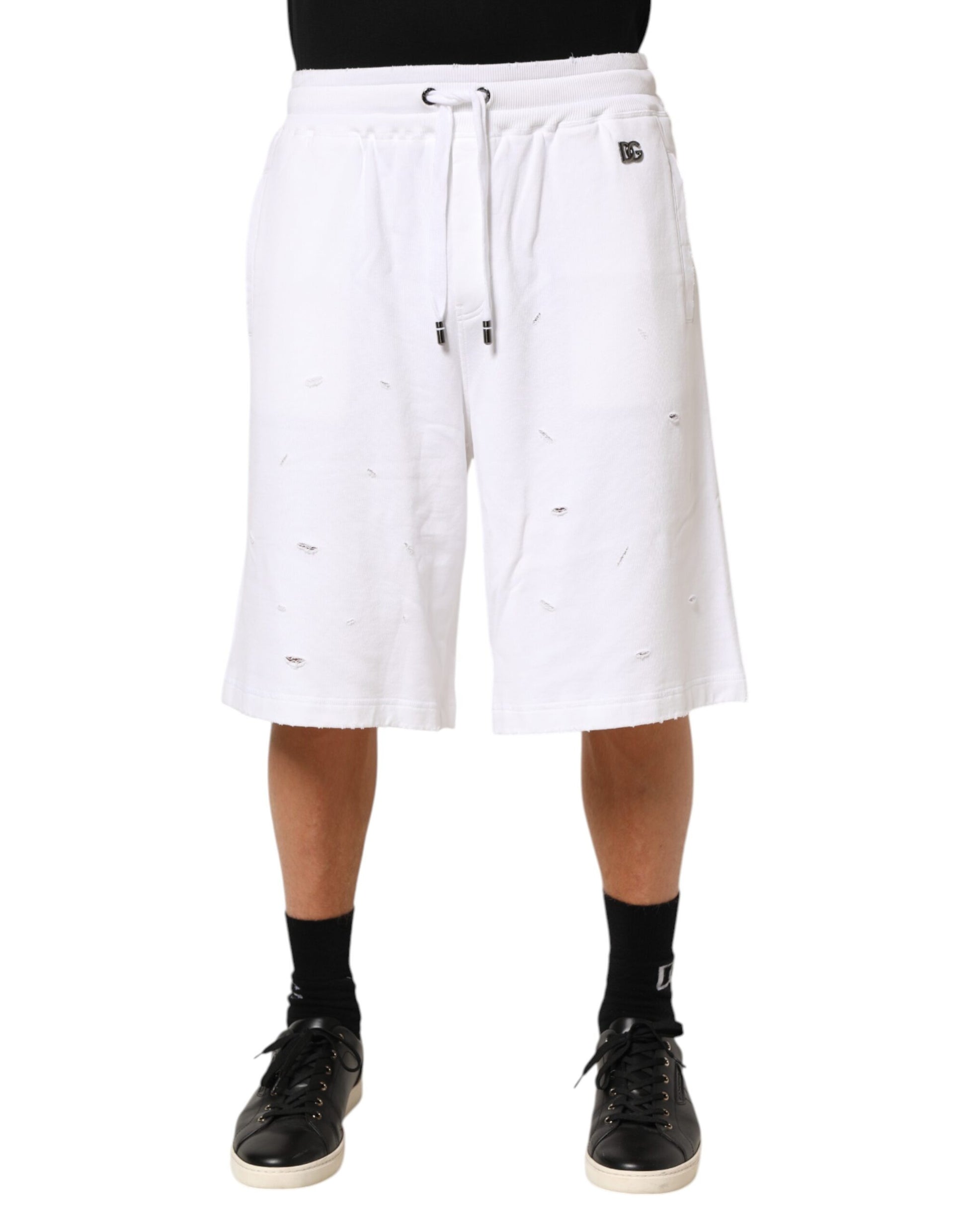 White shorts with holes on a person wearing black shoes