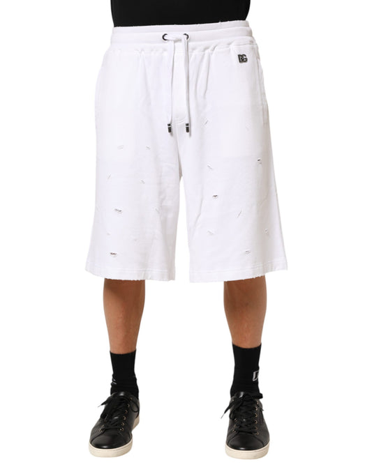 White shorts with holes on a person wearing black shoes