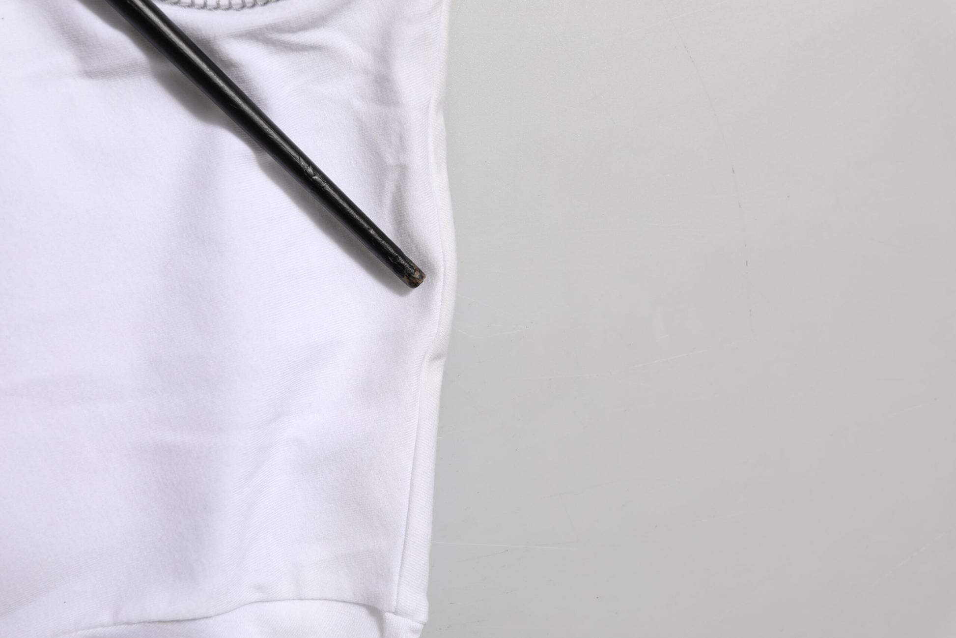White t-shirt on table next to black pen