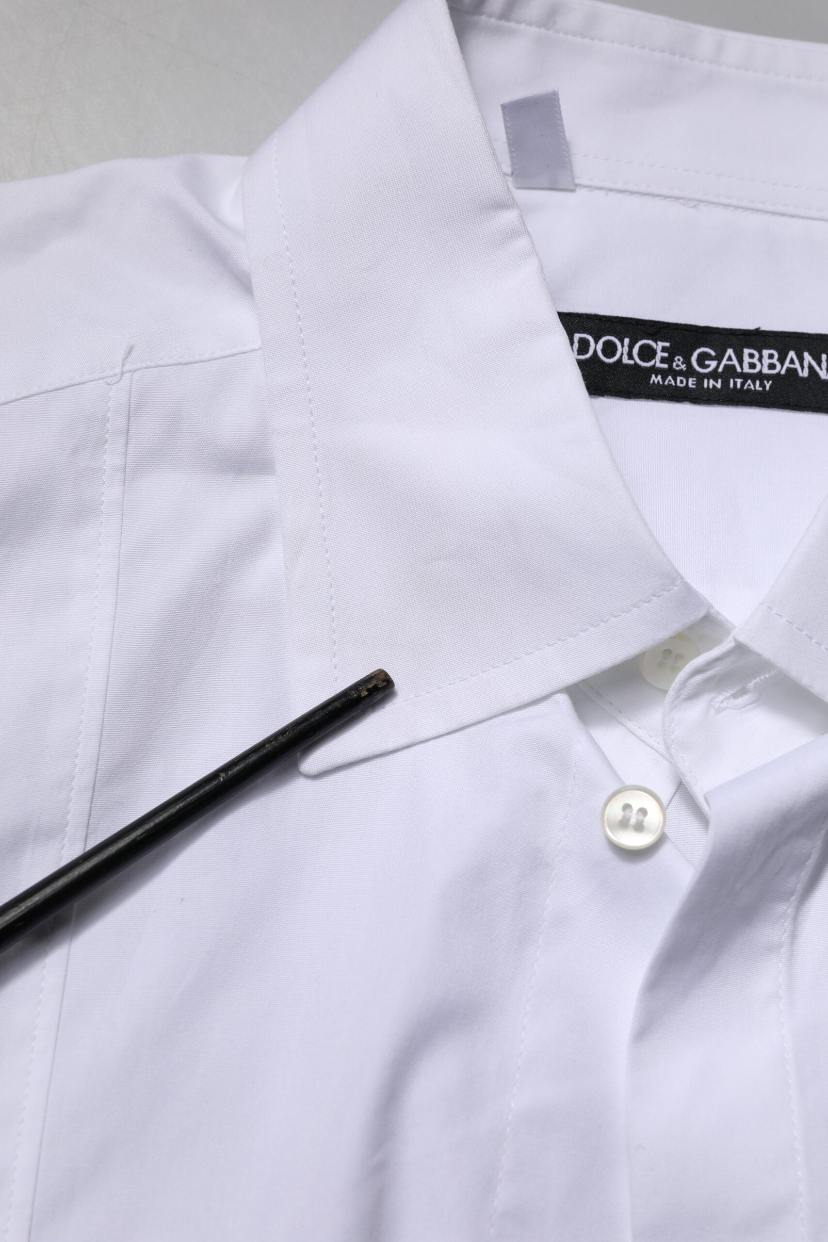 White shirt on hanger with black button