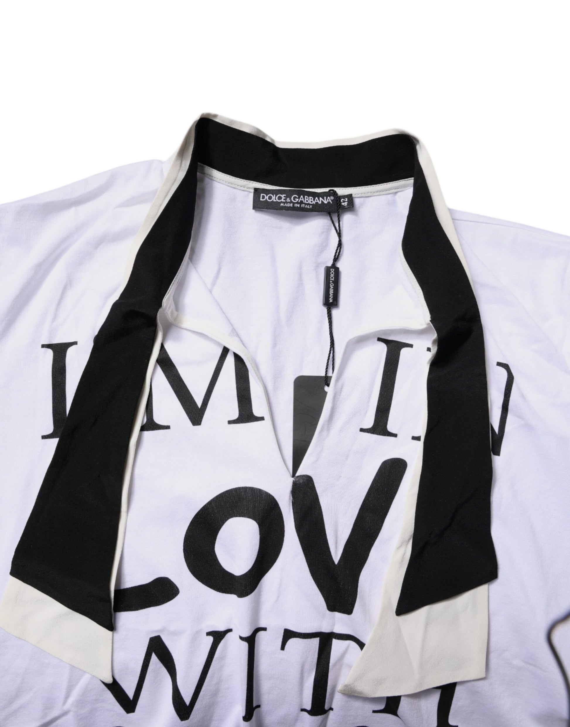 White t-shirt with black lettering and a black scarf