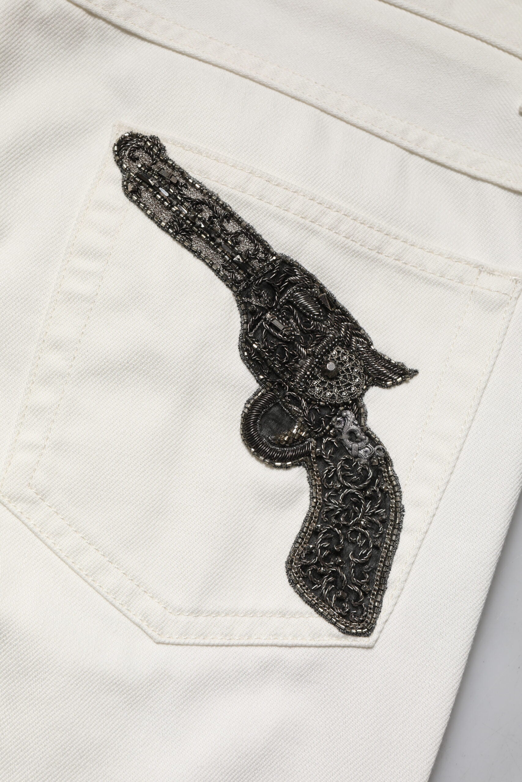 Black gun embroidered on white fabric