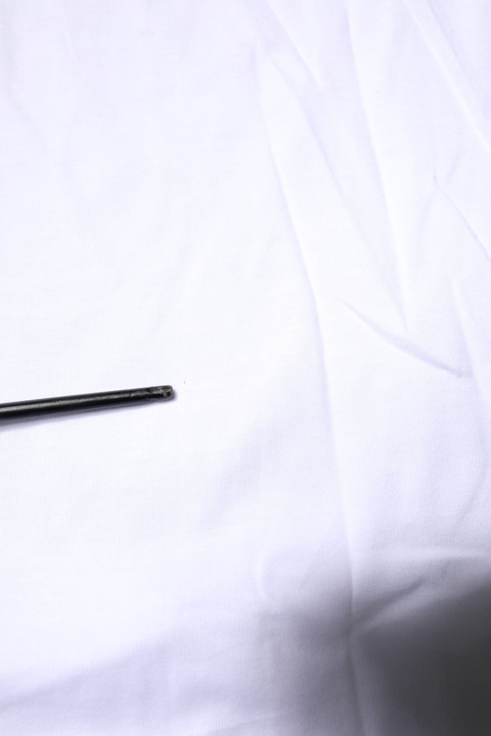 Small black pin on white fabric