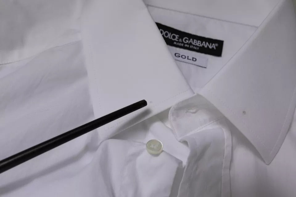 A white cotton dress shirt with a slim fit, featuring a gold label that reads "Dolce & Gabbana" and the word "GOLD"