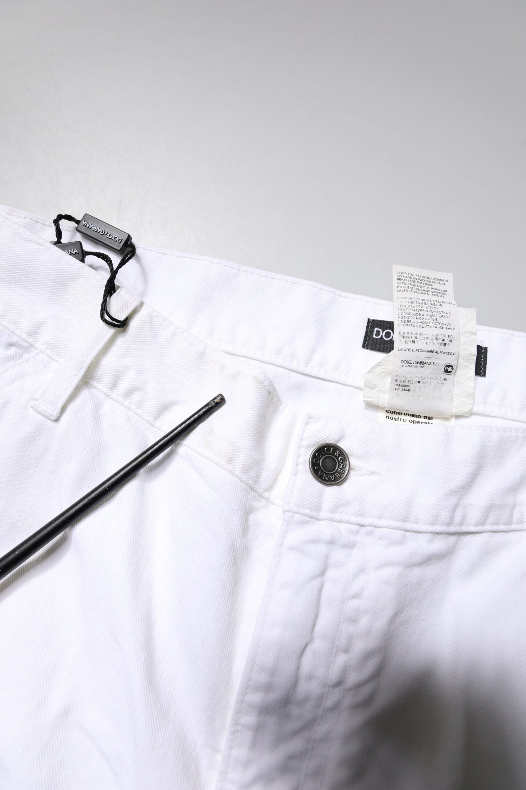 White pants on hanger with tag