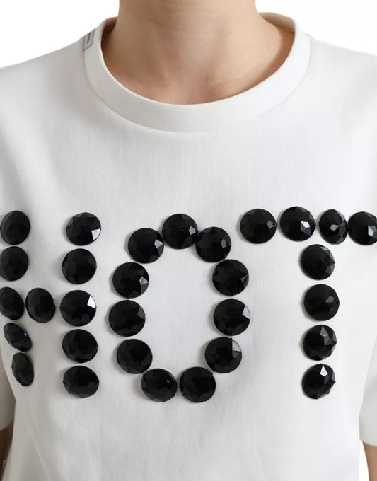 White sweater with black letters spelling "NOT" and black beads forming the word
