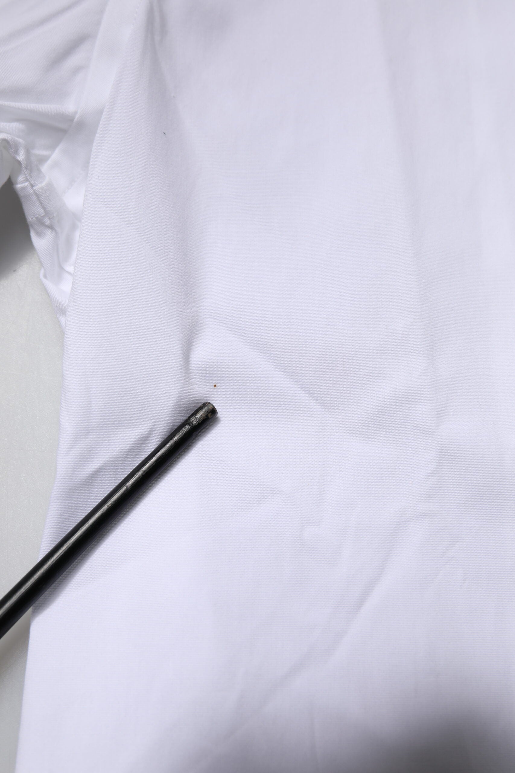 A white cotton stretch dress with gold detailing, part of a formal shirt collection by Dolce & Gabbana