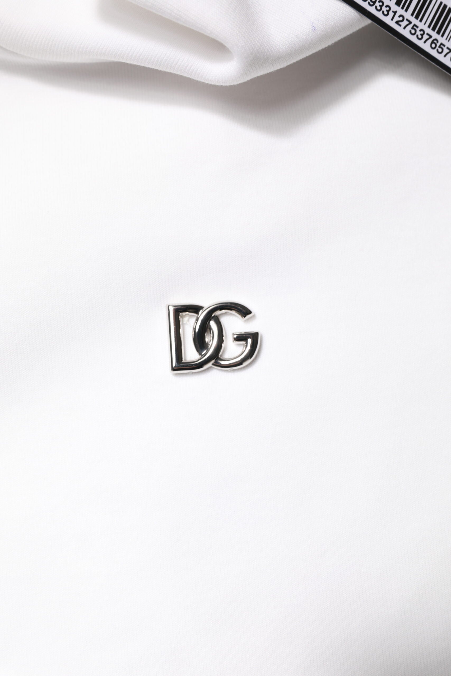 Small silver logo on white fabric