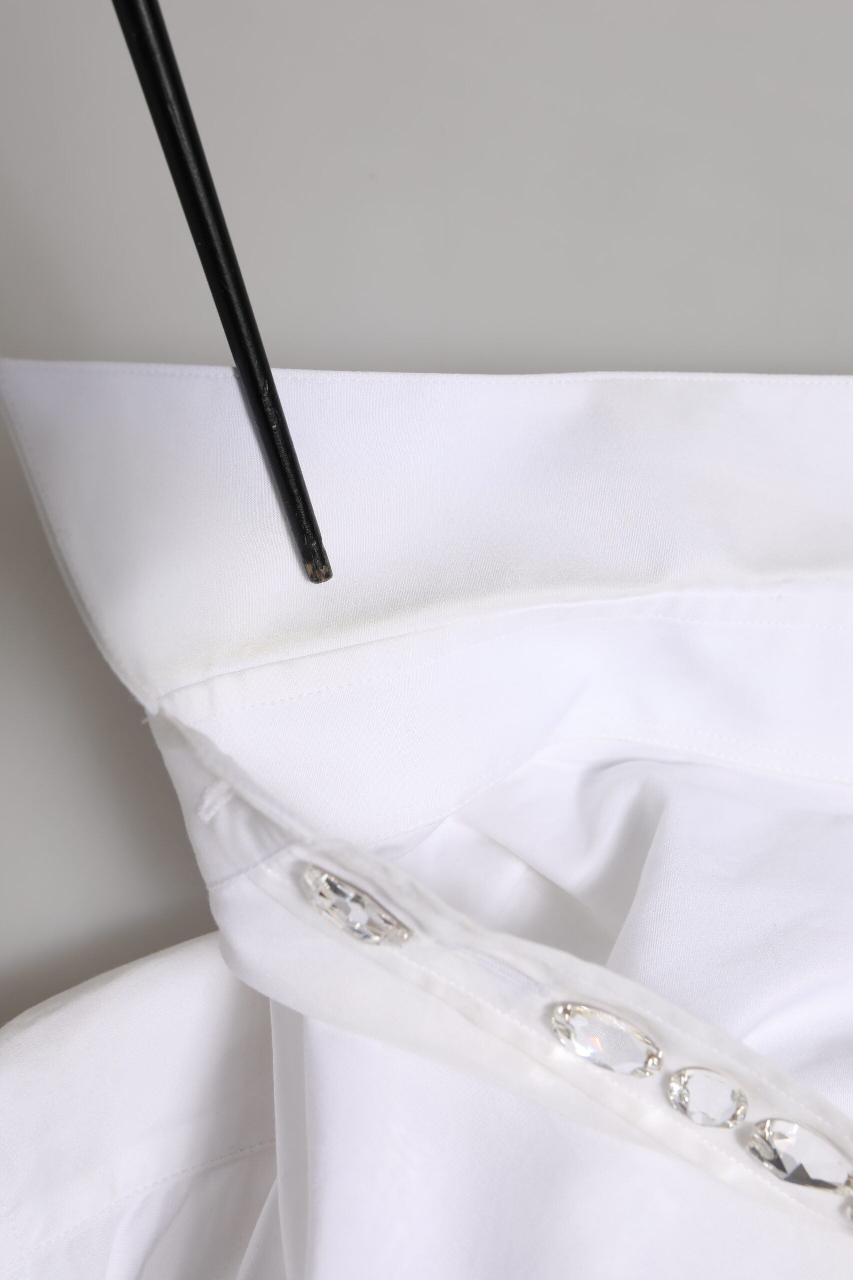 A white dress shirt with crystal embellishments on the collar and sleeves