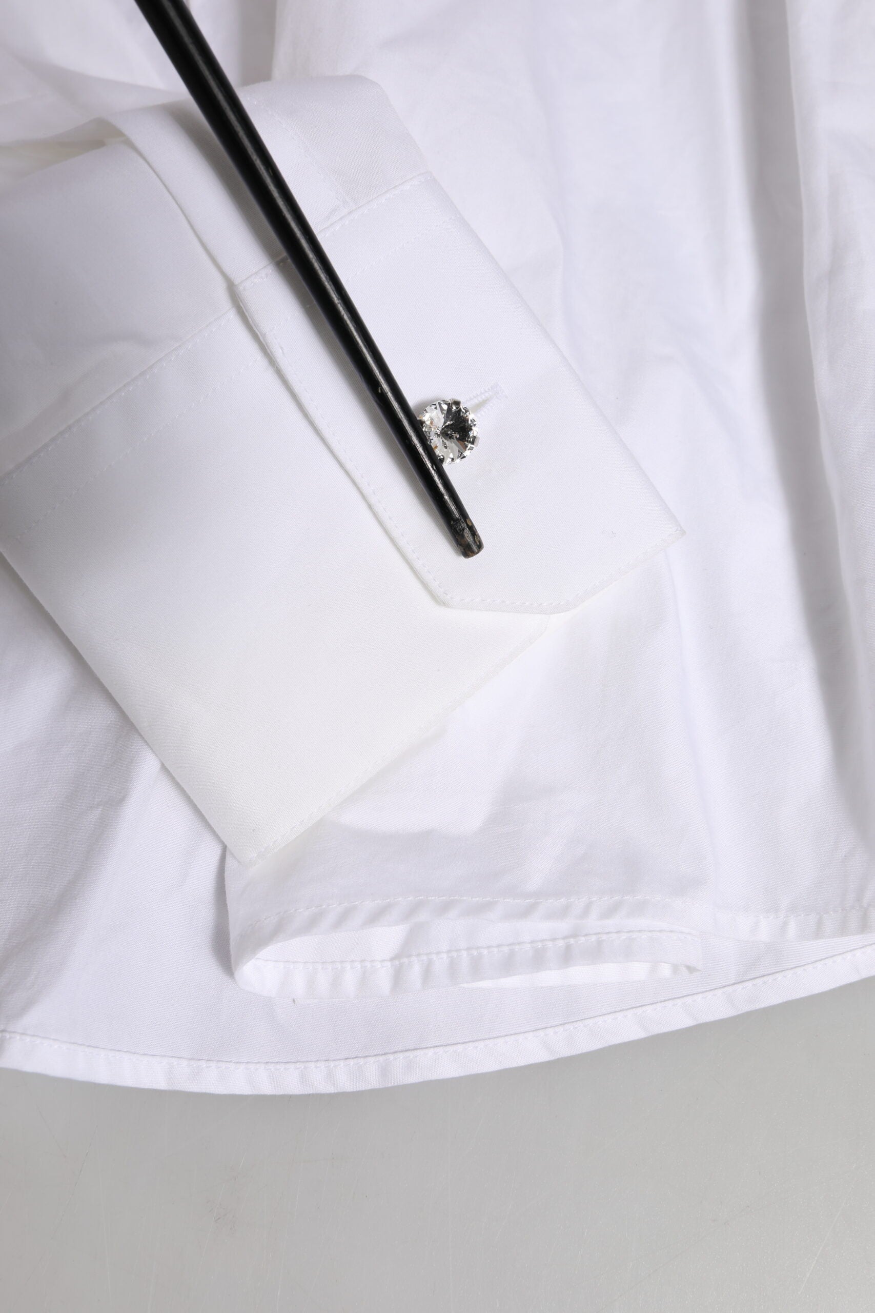 A white dress shirt with crystal embellishments on the collar and sleeves