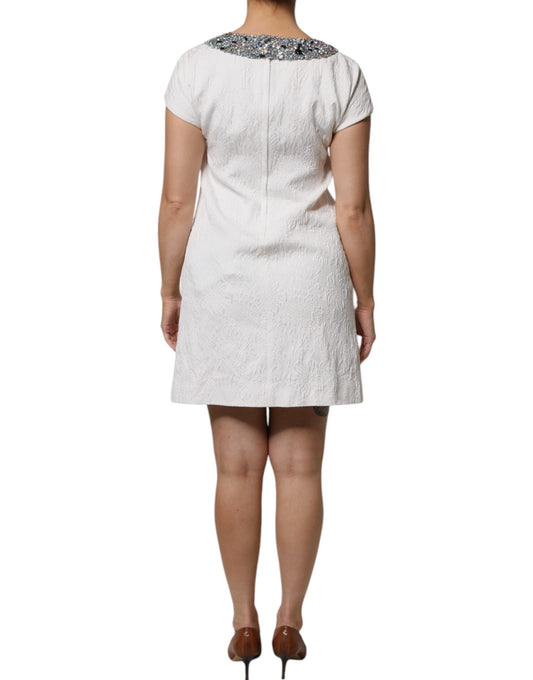 A white dress with crystal embellishments and a jacquard brocade pattern