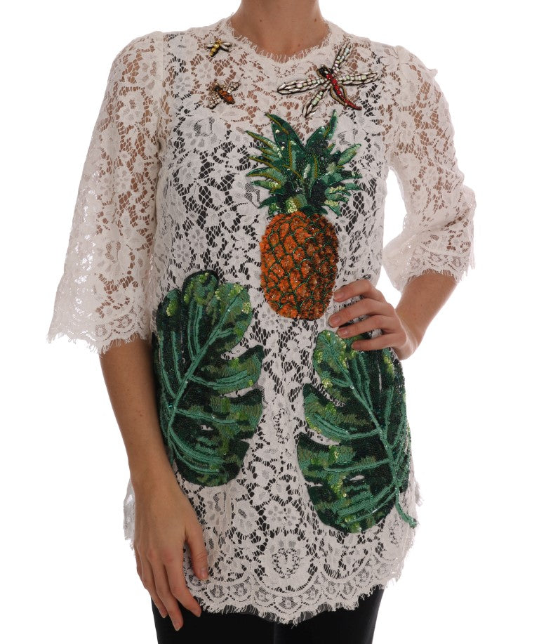Woman wearing a lace top with pineapple and palm tree embroidery