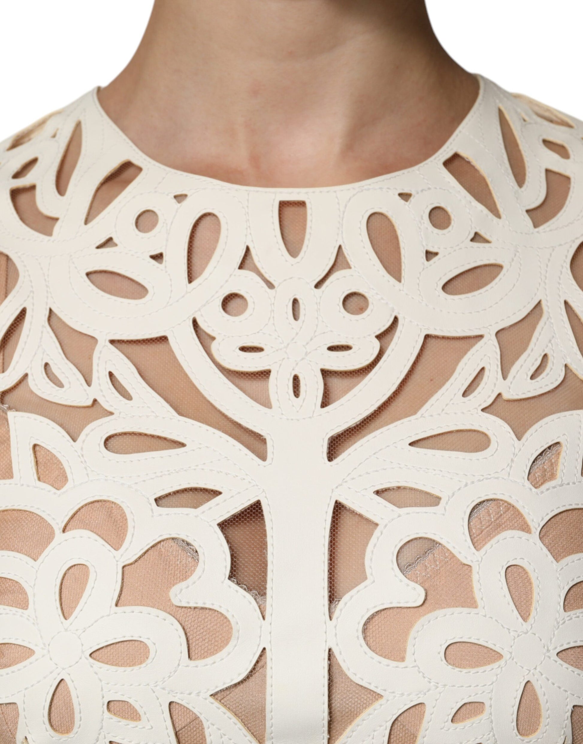 A white cut out leather sleeveless midi dress with intricate designs