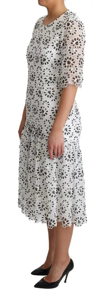 A white midi dress with cutout design and lace detailing. It is made of polyester and features an A-line silh