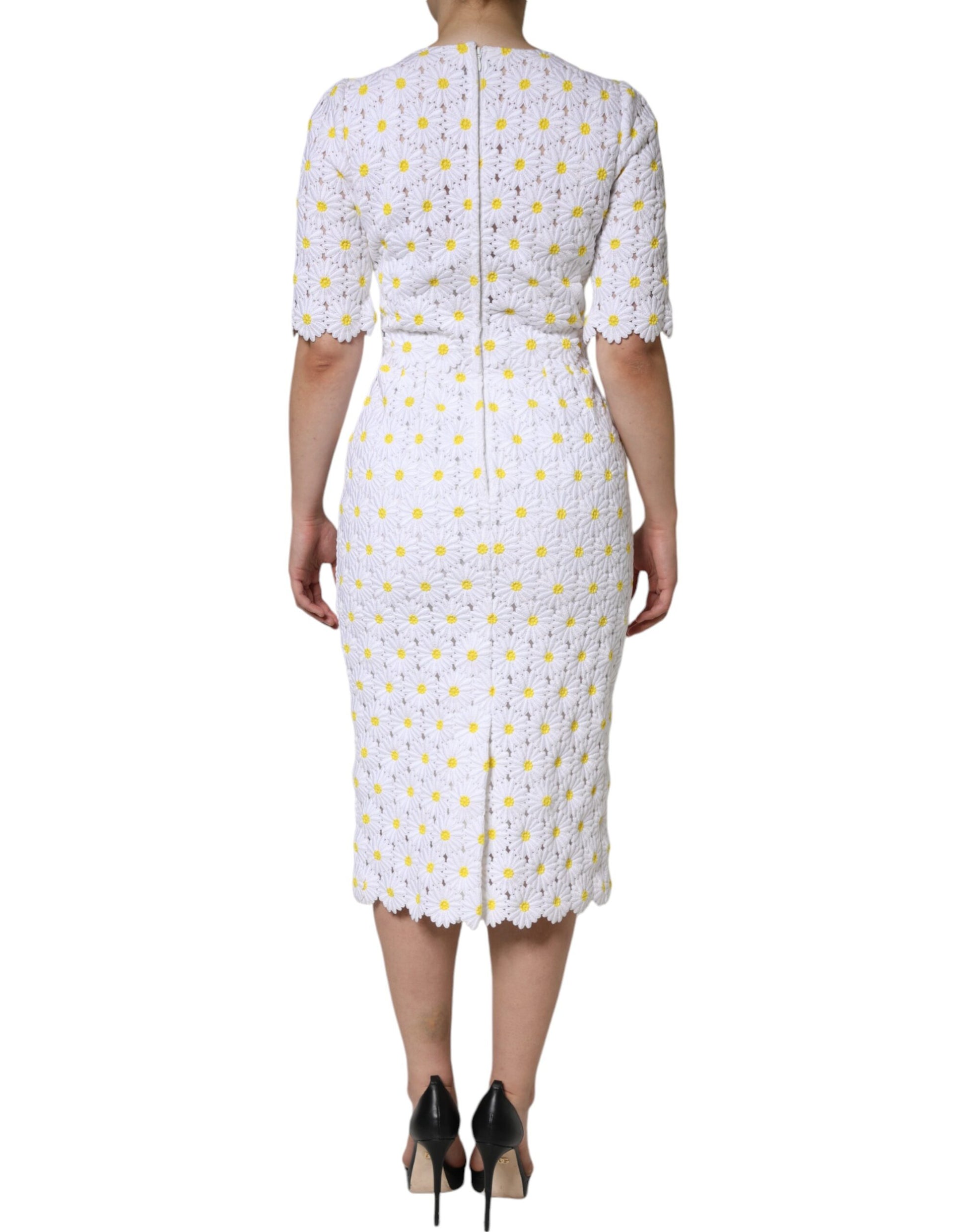 A white midi dress with macramé lace and daisy pattern, worn by a mannequin