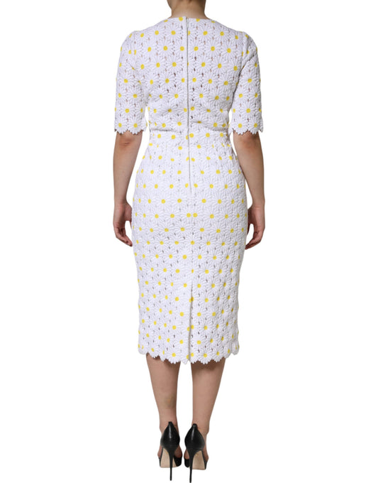 A white midi dress with macramé lace and daisy pattern, worn by a mannequin