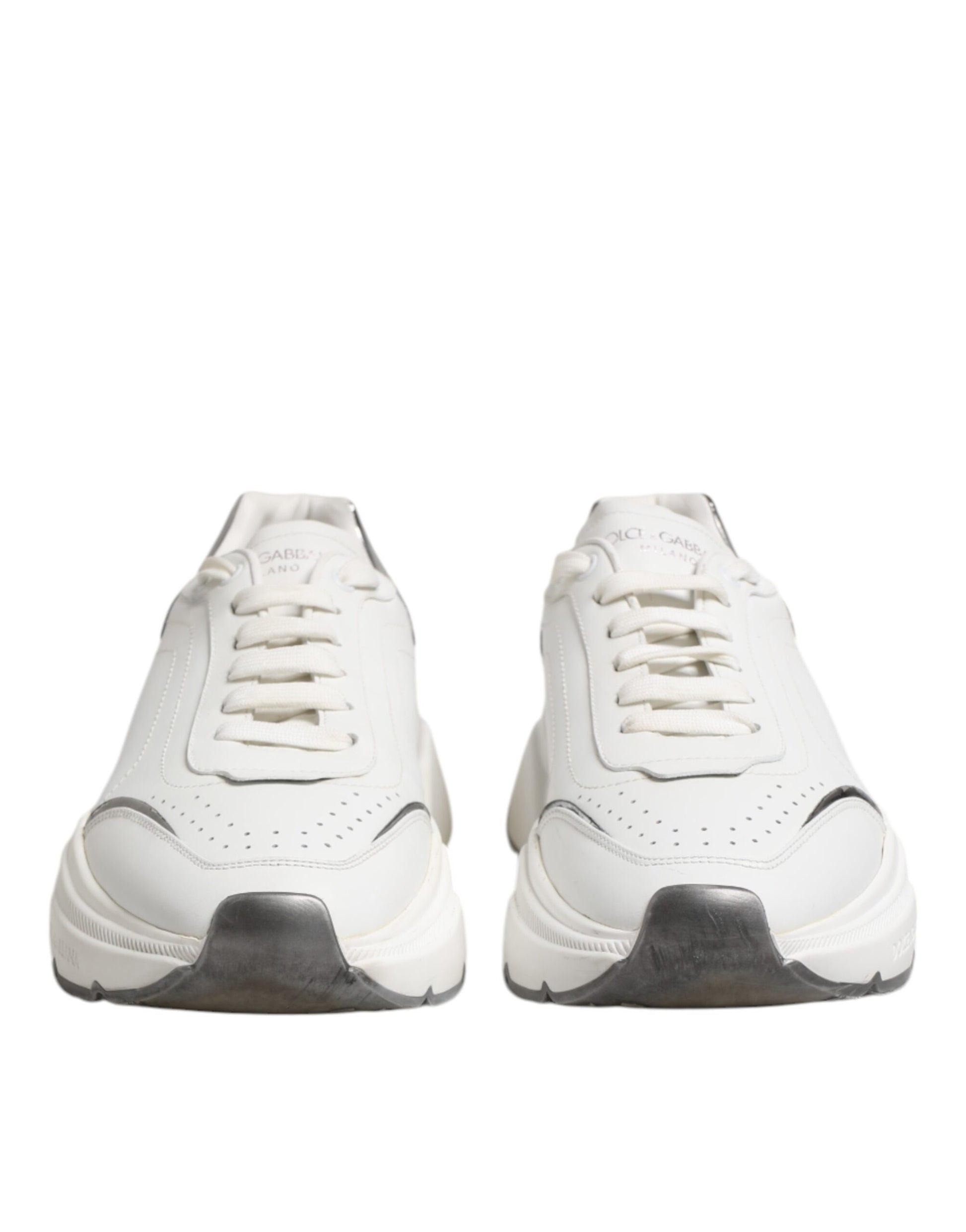 Pair of white leather sneakers with black laces and soles, featuring a low top design