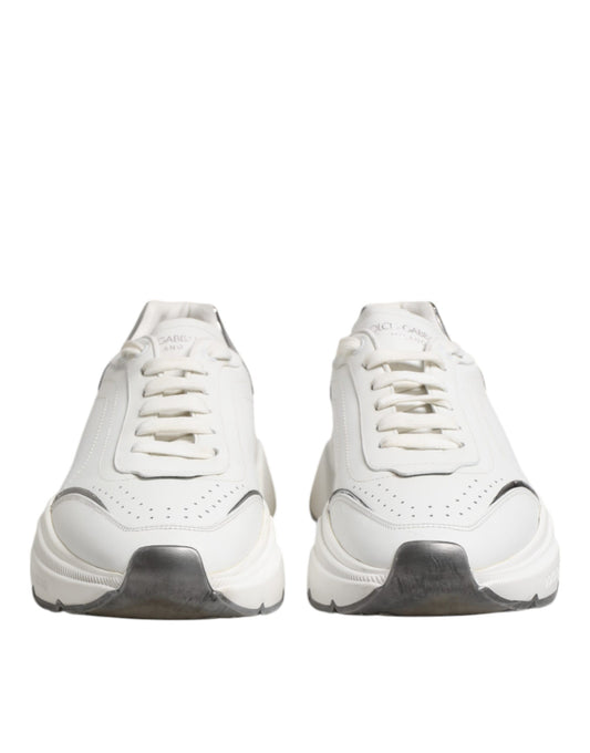 Pair of white leather sneakers with black laces and soles, featuring a low top design