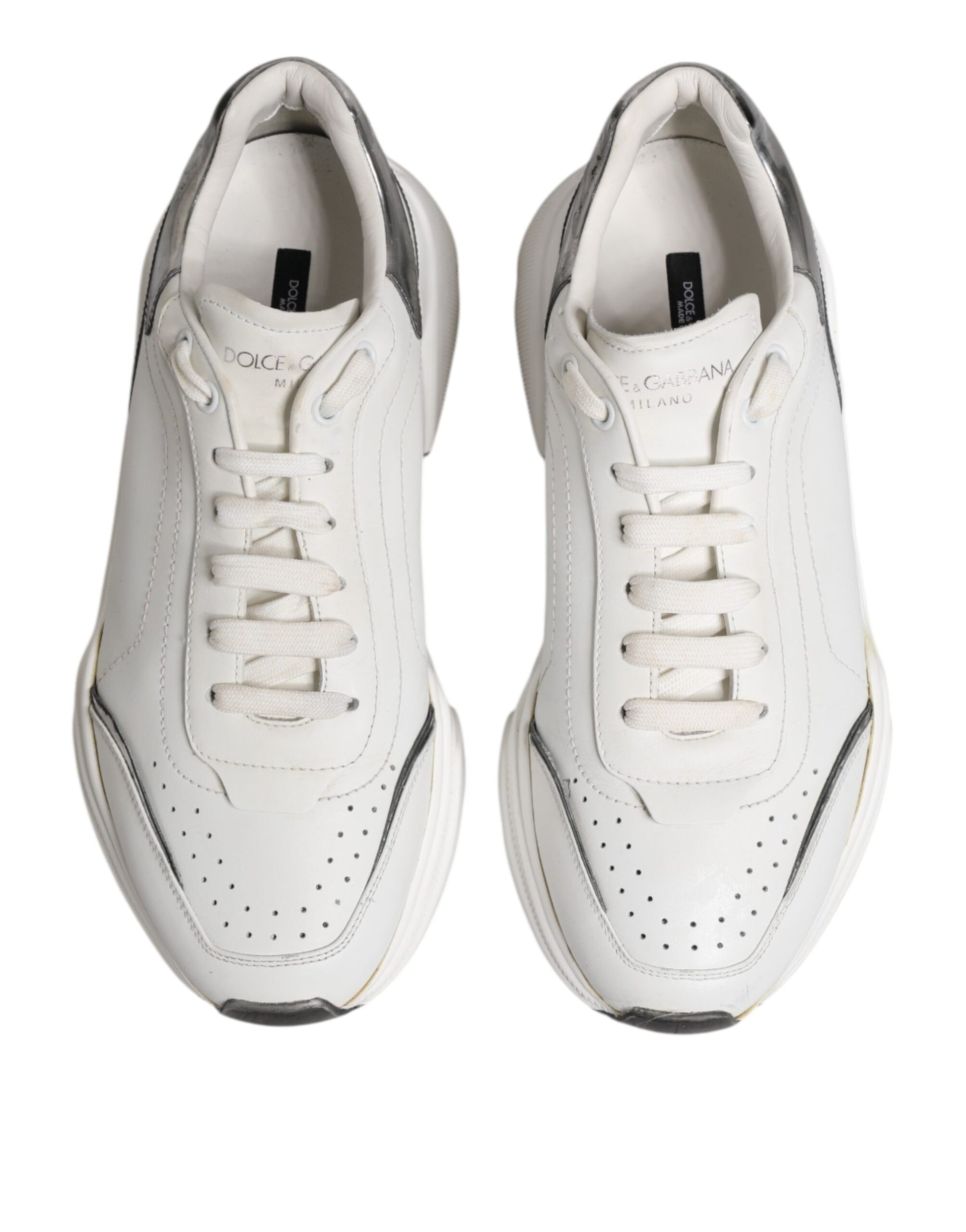 Pair of white leather sneakers with black laces and logo, low top style